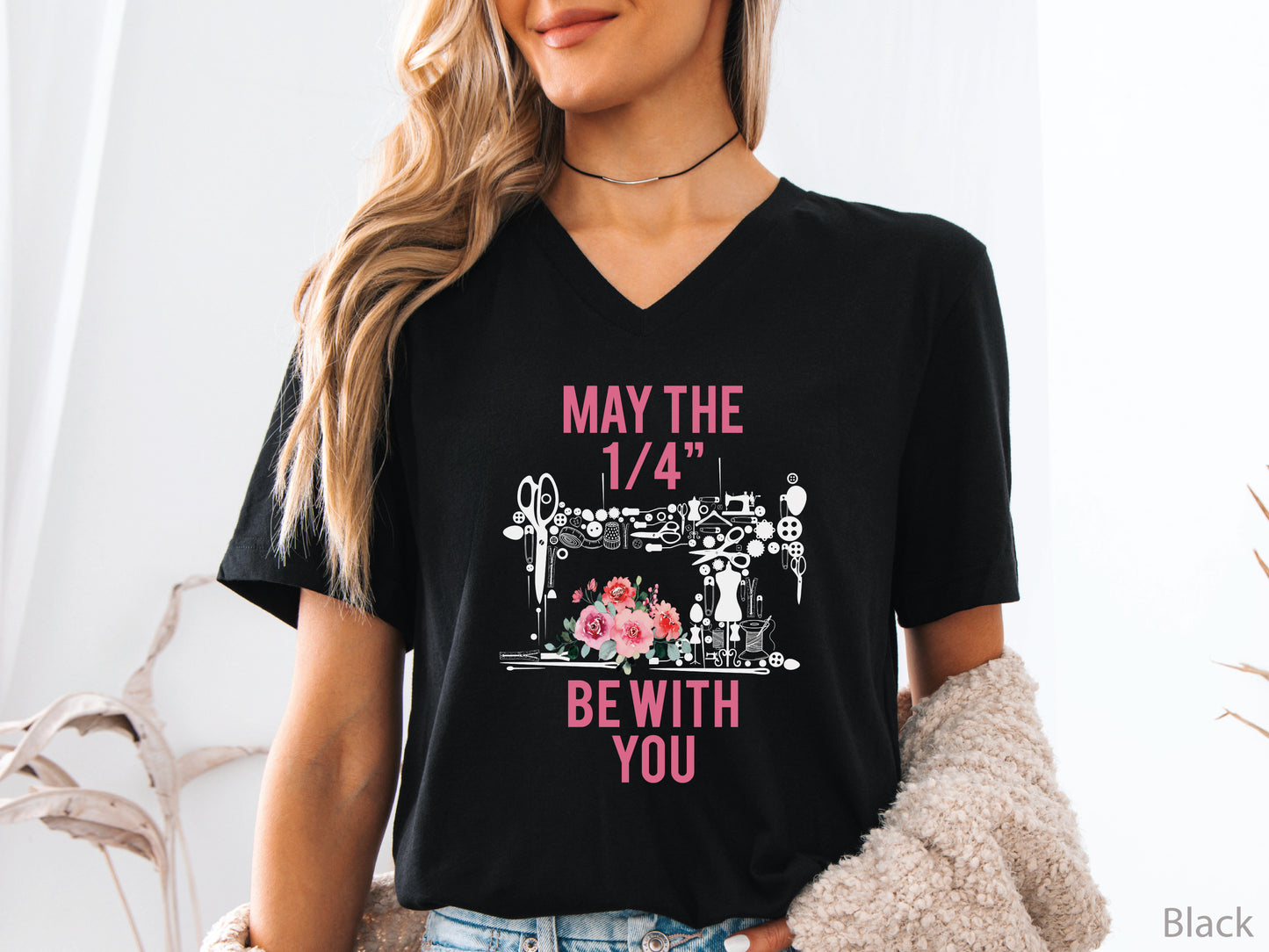 V-neck t-shirt with “May the 1/4” Be With You” quilting design featuring sewing tools arranged in a sewing machine shape with floral accents, ideal for quilters and sewing enthusiasts.