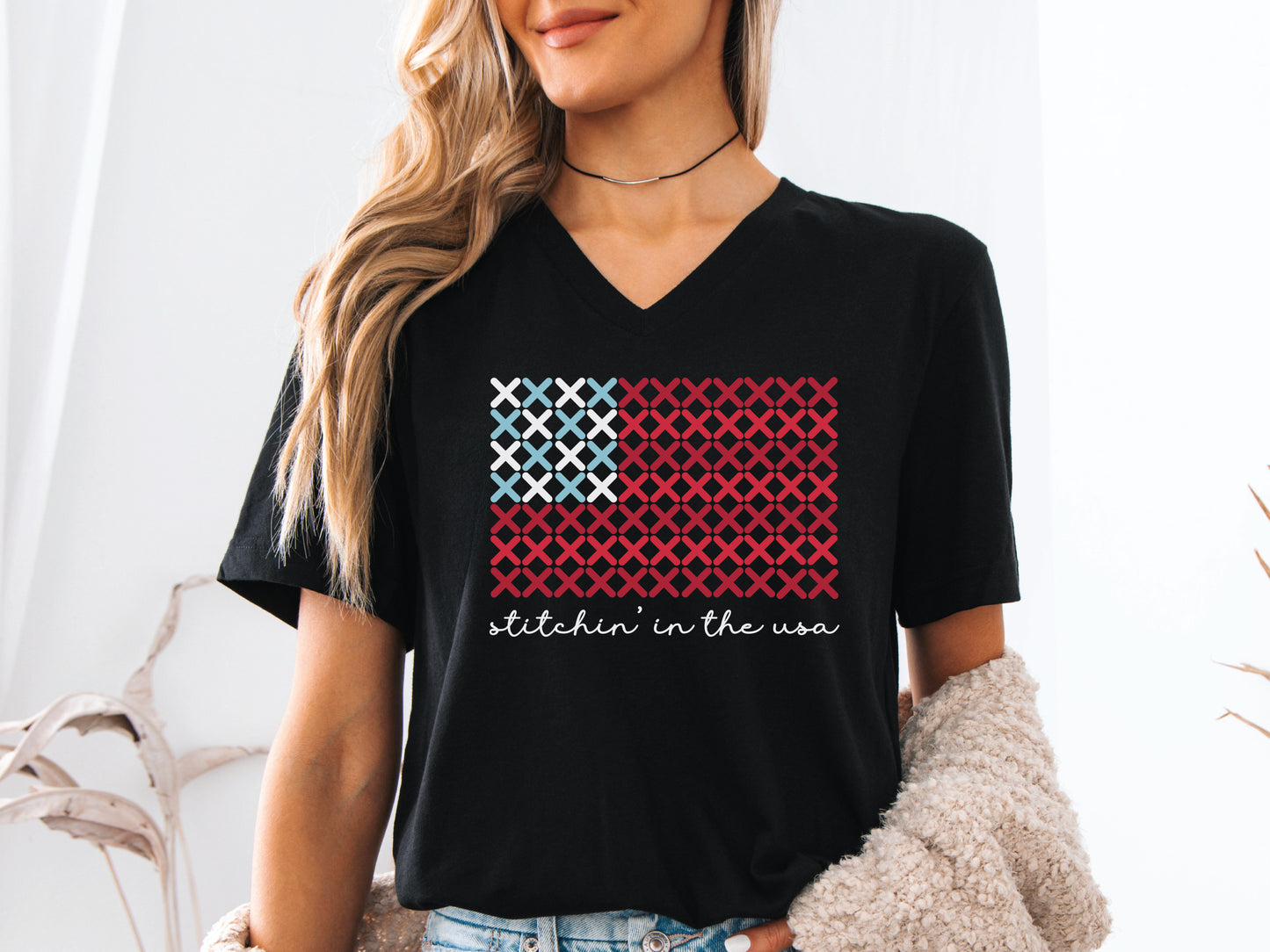 The “Stitchin’ in the USA” is a cross stitch t-shirt in red, white, and blue. The design is "x's" in the shape of a flag. 