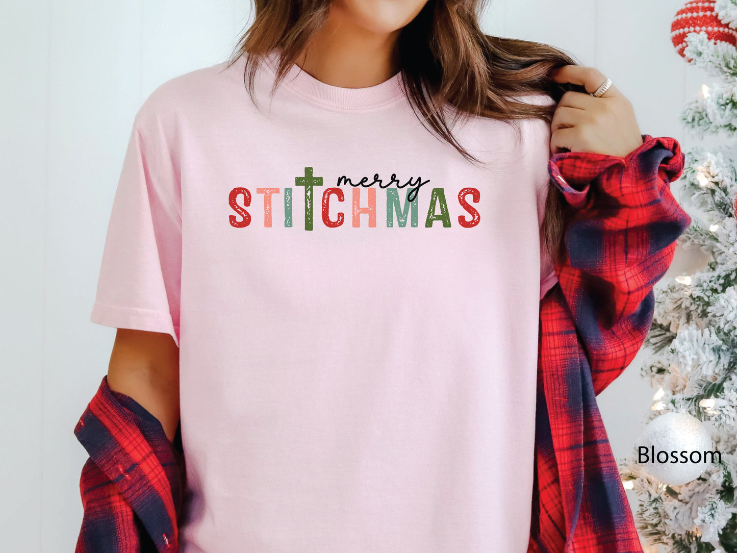 Merry Stitchmas t-shirt featuring the word STITCHMAS with a cross-shaped T, a festive holiday design for quilters, sewists, and makers who love stitching and faith.