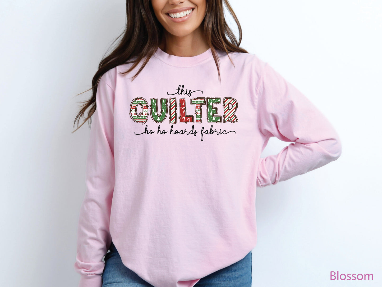 This Quilter Ho Ho Hoards Fabric long sleeve t-shirt with red and green patchwork lettering, a funny Christmas shirt for quilters who love fabric, sewing, and holiday cheer.