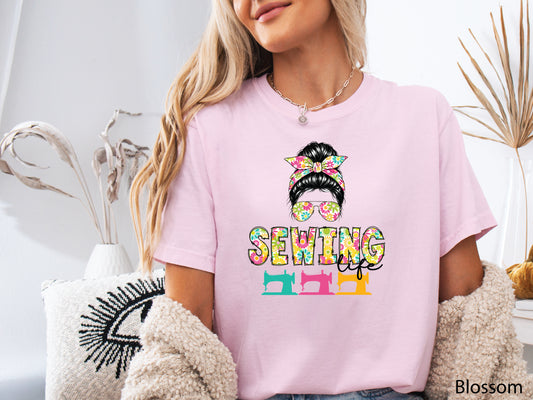 Sewing Life t-shirt featuring a stylish messy bun with a colorful floral headband, matching floral sunglasses, vibrant lettering, and three vintage-inspired sewing machines.