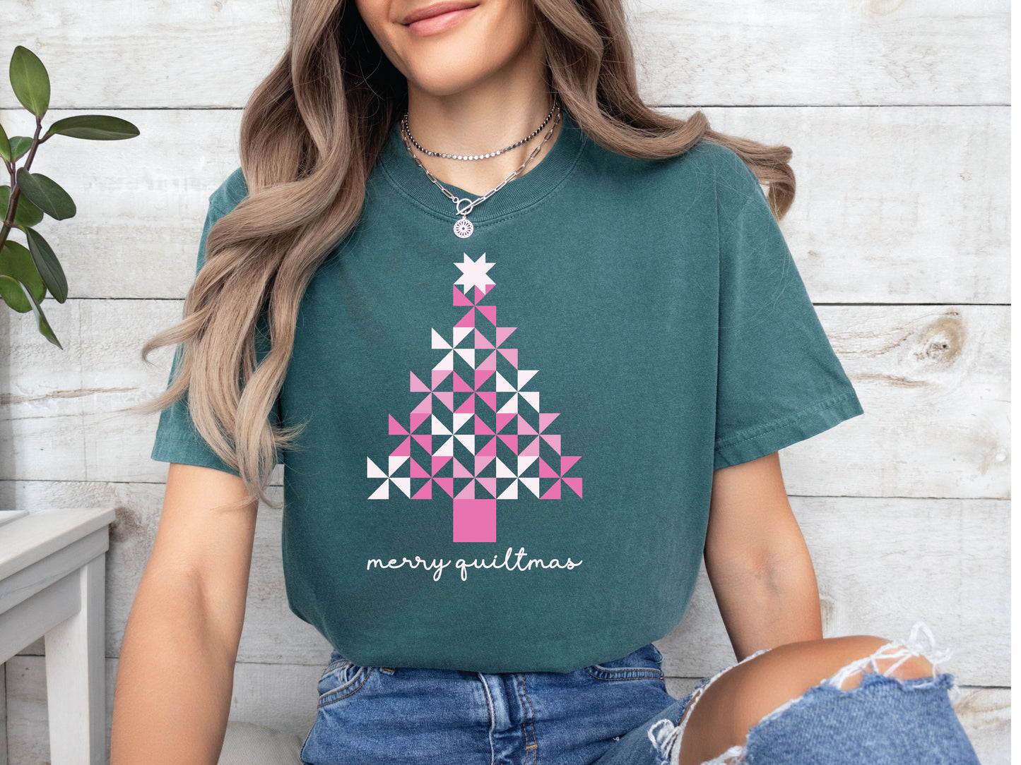 A Christmas tree made of pink pinwheel quilt blocks with the phrase “Merry Quiltmas,” printed on a festive V-Neck T-shirt for quilters who love handmade holiday cheer.