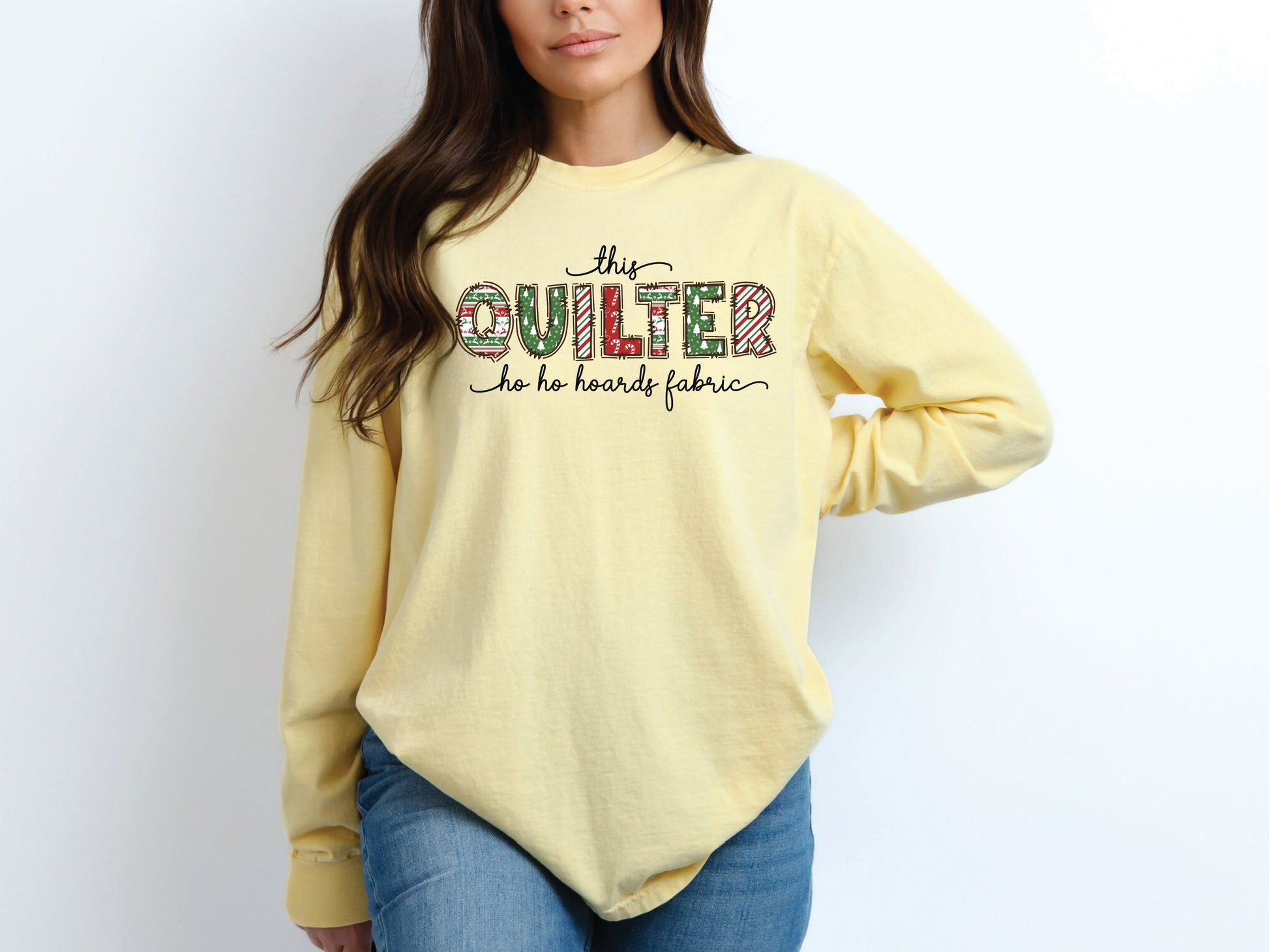 This Quilter Ho Ho Hoards Fabric long sleeve t-shirt with red and green patchwork lettering, a funny Christmas shirt for quilters who love fabric, sewing, and holiday cheer.