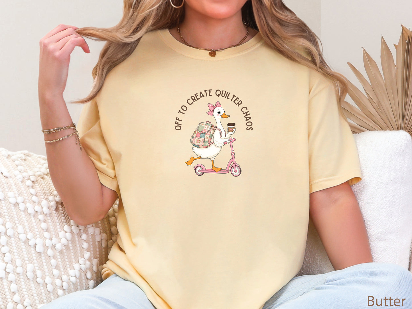 Funny quilting t-shirt featuring a goose riding a pink scooter with coffee and a patchwork backpack, paired with the saying “Off To Create Quilter Chaos.” Perfect for quilters, sewists, quilt retreats, and fabric lovers.