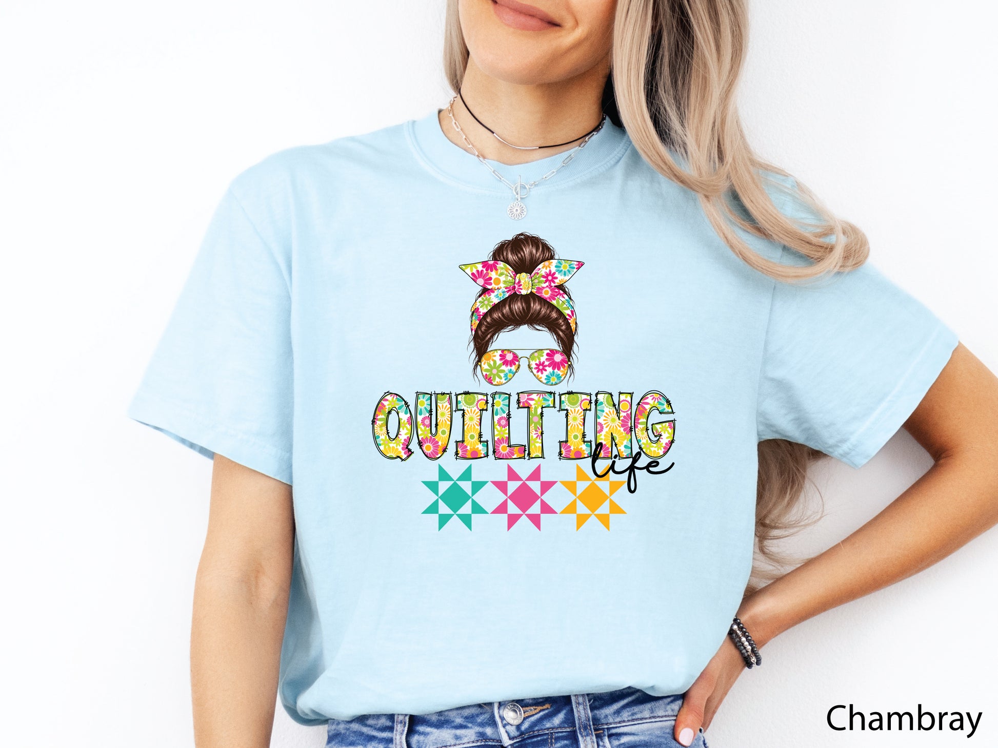 Celebrate your love of quilting with this cheerful Quilting Life t-shirt! Featuring a stylish messy bun, colorful floral headband, coordinating sunglasses, and bright quilt block accents, this fun design is perfect for quilters, fabric lovers, and anyone who feels most at home in their sewing room.