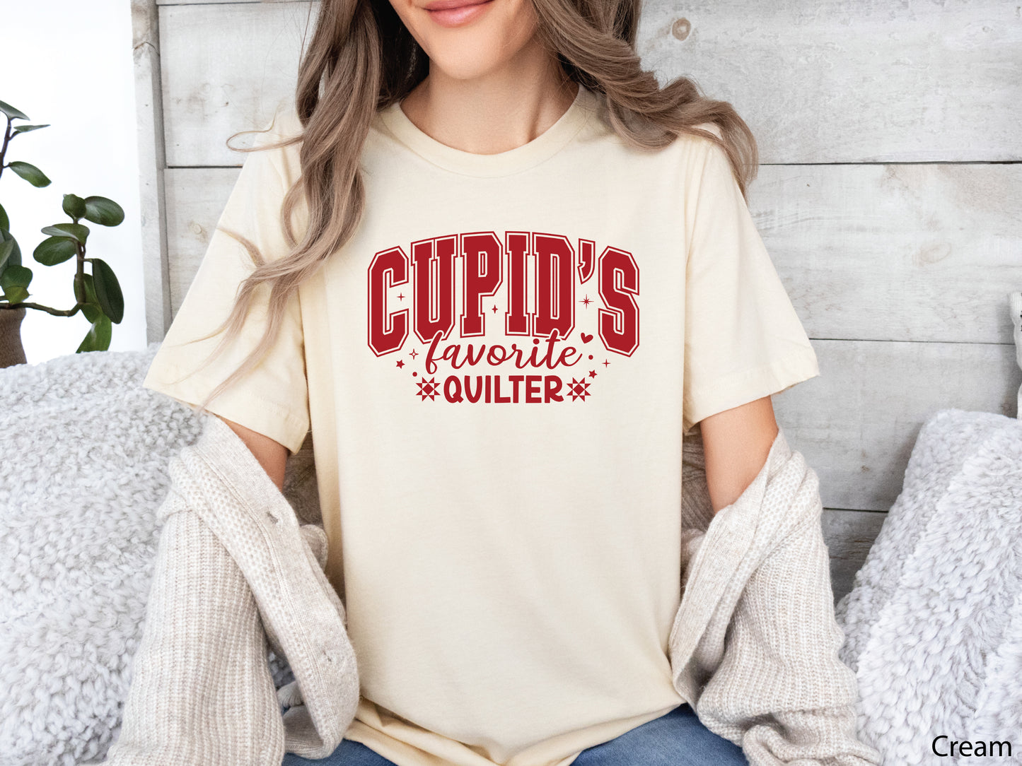 Valentine’s Day quilting t-shirt with “Cupid’s Favorite Quilter” phrase in varsity-style lettering and quilt-inspired details, perfect for quilters.