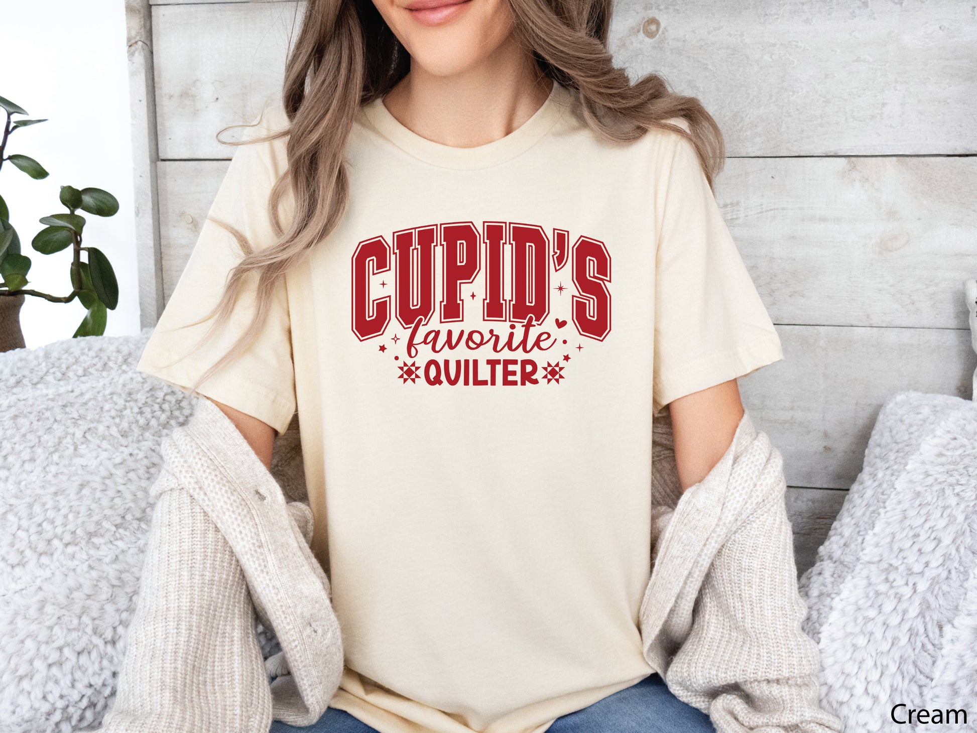 Valentine’s Day quilting t-shirt with “Cupid’s Favorite Quilter” phrase in varsity-style lettering and quilt-inspired details, perfect for quilters.