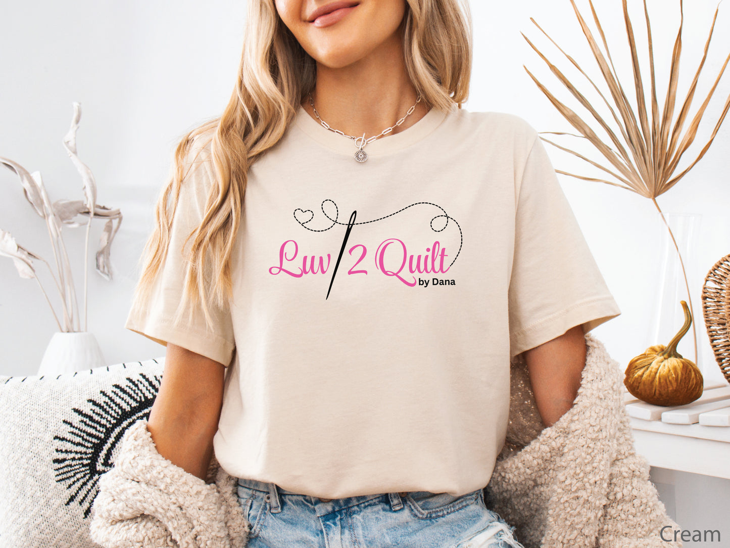 Official Luv2Quilt by Dana quilting-themed t-shirt featuring the Luv2Quilt logo with a sewing needle and stitched heart design, perfect for quilt classes, retreats, and everyday wear.