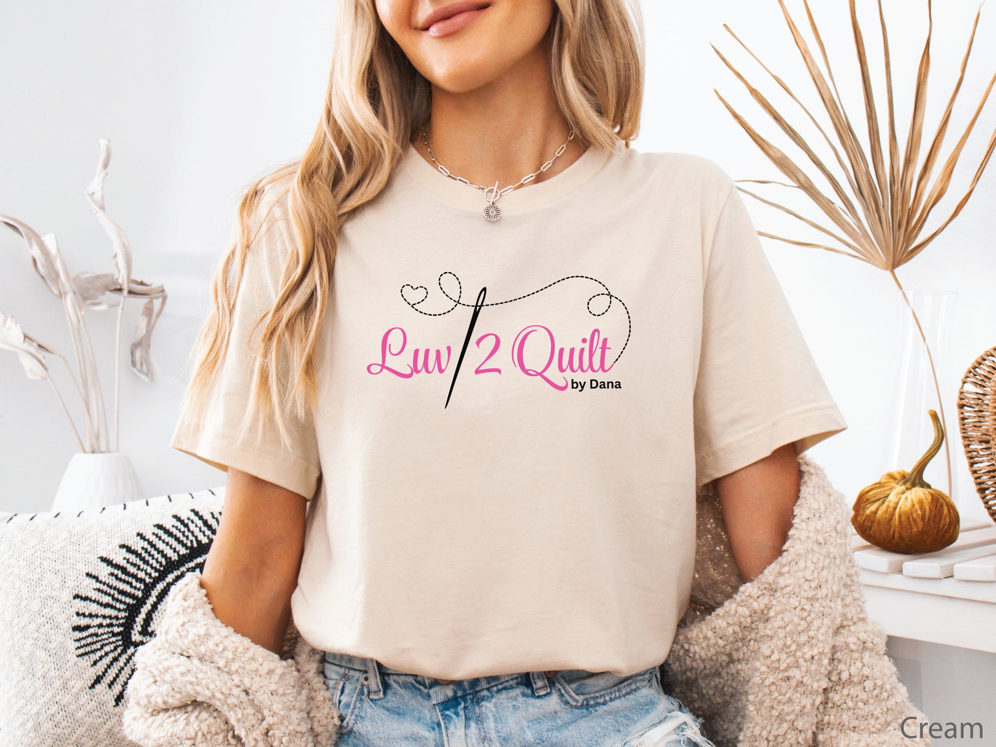 Official Luv2Quilt by Dana quilting-themed t-shirt featuring the Luv2Quilt logo with a sewing needle and stitched heart design, perfect for quilt classes, retreats, and everyday wear.