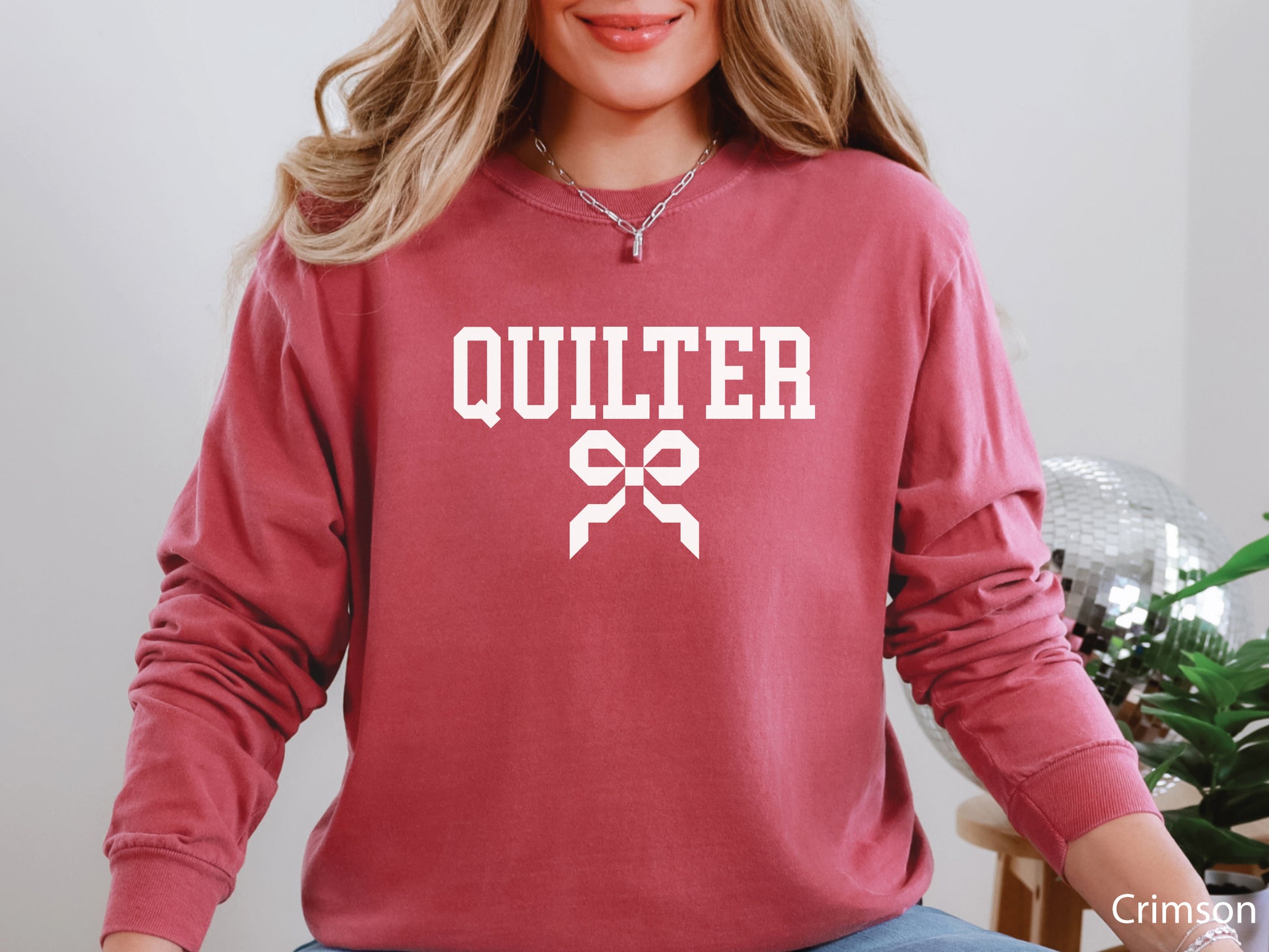 Cozy sweatshirt with bold varsity-style “Quilter” lettering and a coquette bow — perfect for quilt retreats, guild meetings, or as a thoughtful gift for quilters.