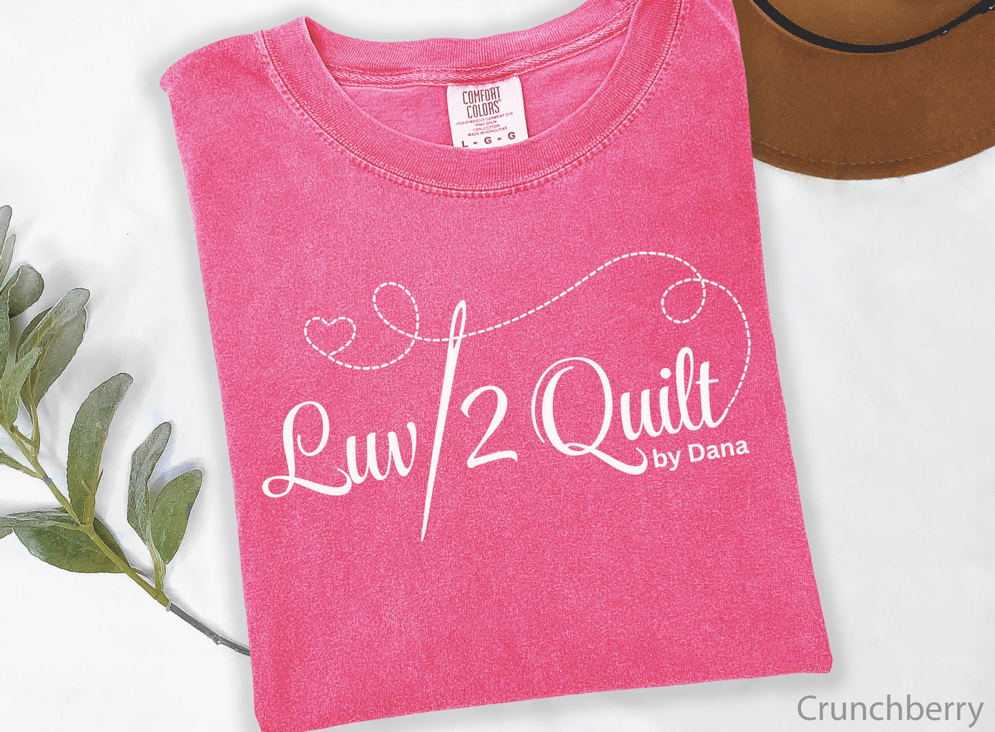 Official Luv2Quilt by Dana quilting-themed t-shirt featuring the Luv2Quilt logo with a sewing needle and stitched heart design, perfect for quilt classes, retreats, and everyday wear.
