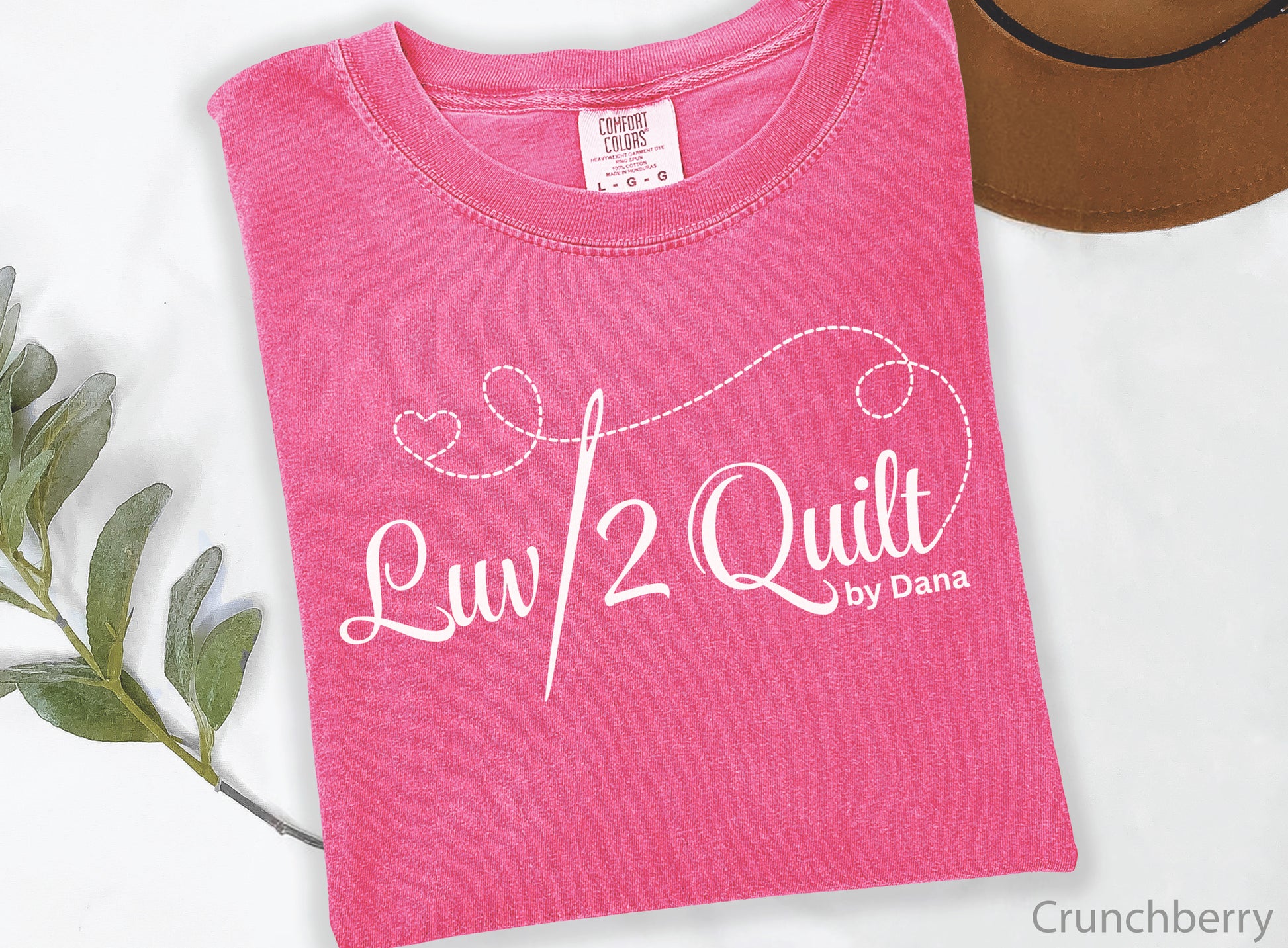 Official Luv2Quilt by Dana quilting-themed t-shirt featuring the Luv2Quilt logo with a sewing needle and stitched heart design, perfect for quilt classes, retreats, and everyday wear.
