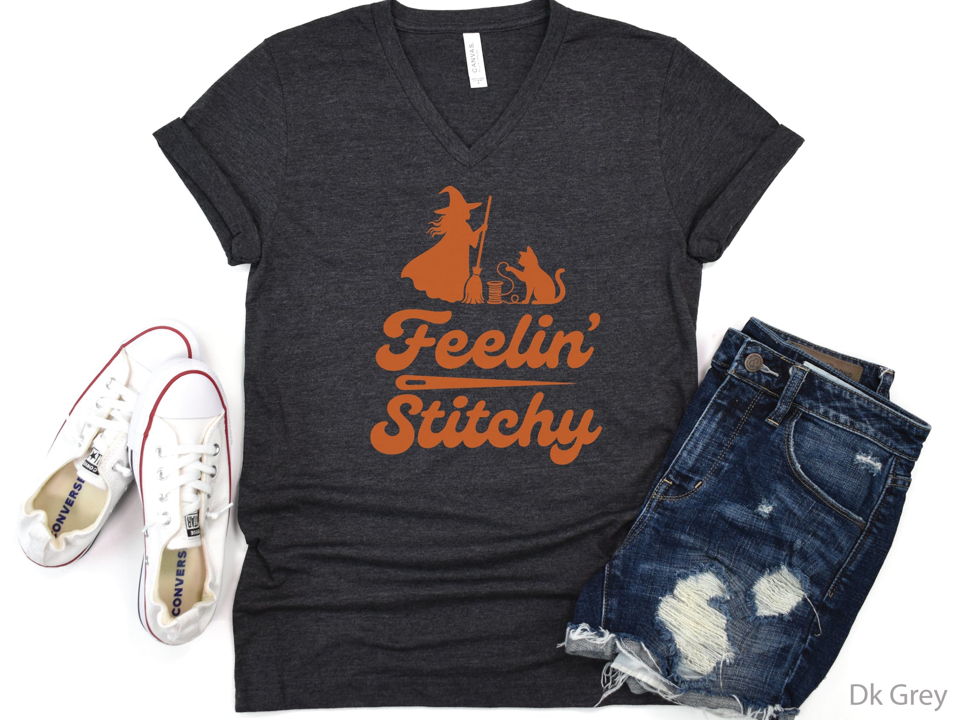 Feelin’ Stitchy Halloween t-shirt featuring a silhouette of a witch with a black cat and spool of thread, designed for sewists, quilters, and stitch witches.