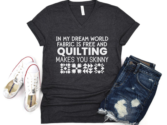 Quilting V-neck t-shirt with the humorous phrase “In My Dream World, Fabric Is Free and Quilting Makes You Skinny,” perfect for quilters and sewing retreats.