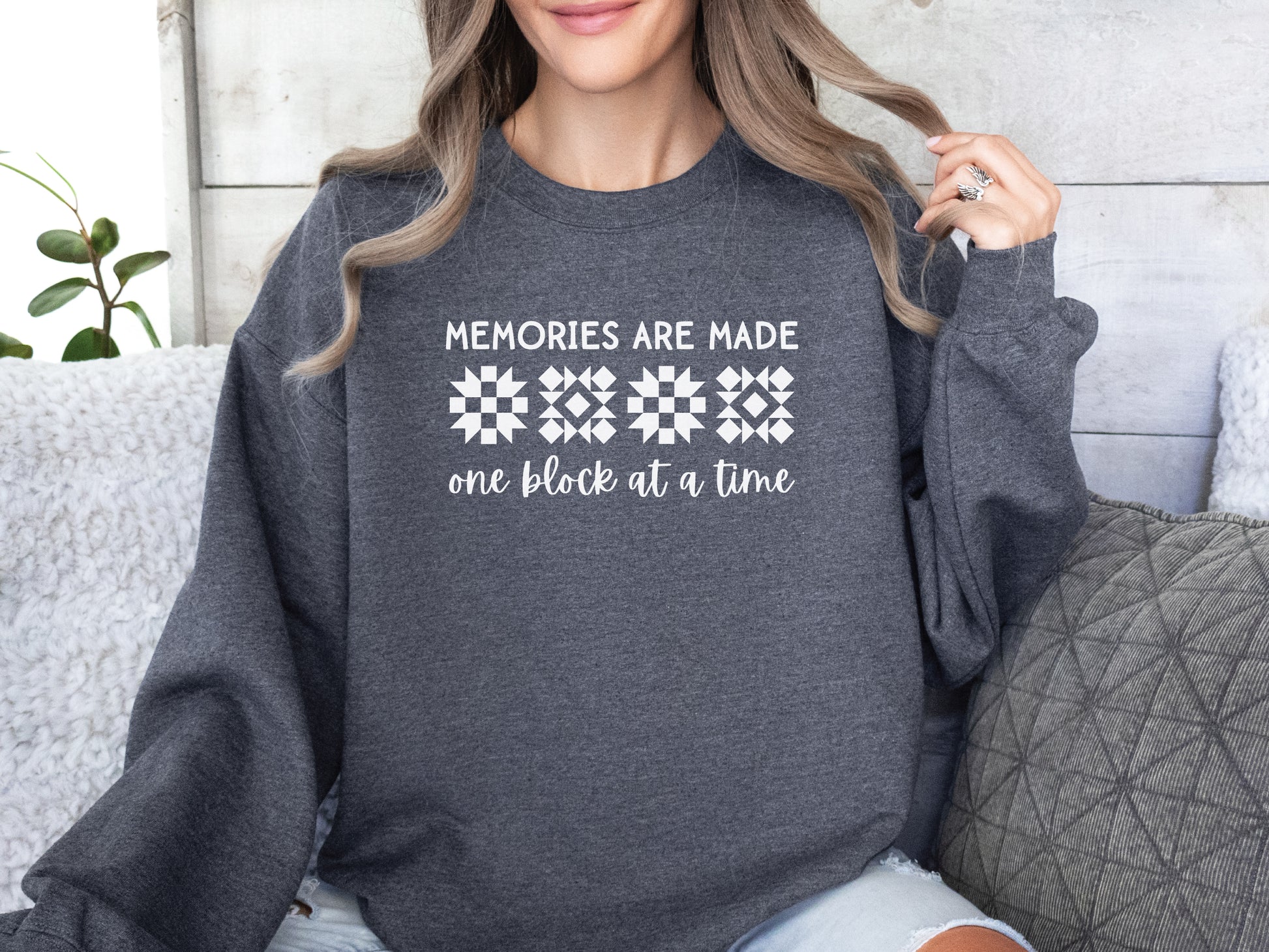 A long-sleeve quilt-themed sweatshirt from Bee Inspired Tees featuring the phrase “Memories Are Made One Block at a Time,” perfect for cozy sewing days, quilt retreats, or gifting to quilters who love celebrating their craft.