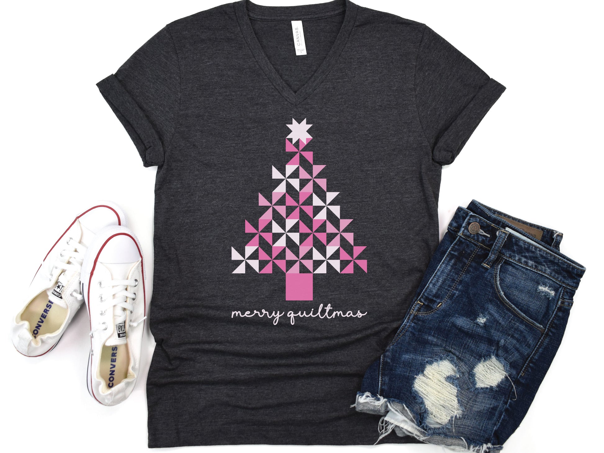 A Christmas tree made of pink pinwheel quilt blocks with the phrase “Merry Quiltmas,” printed on a festive V-Neck T-shirt for quilters who love handmade holiday cheer.