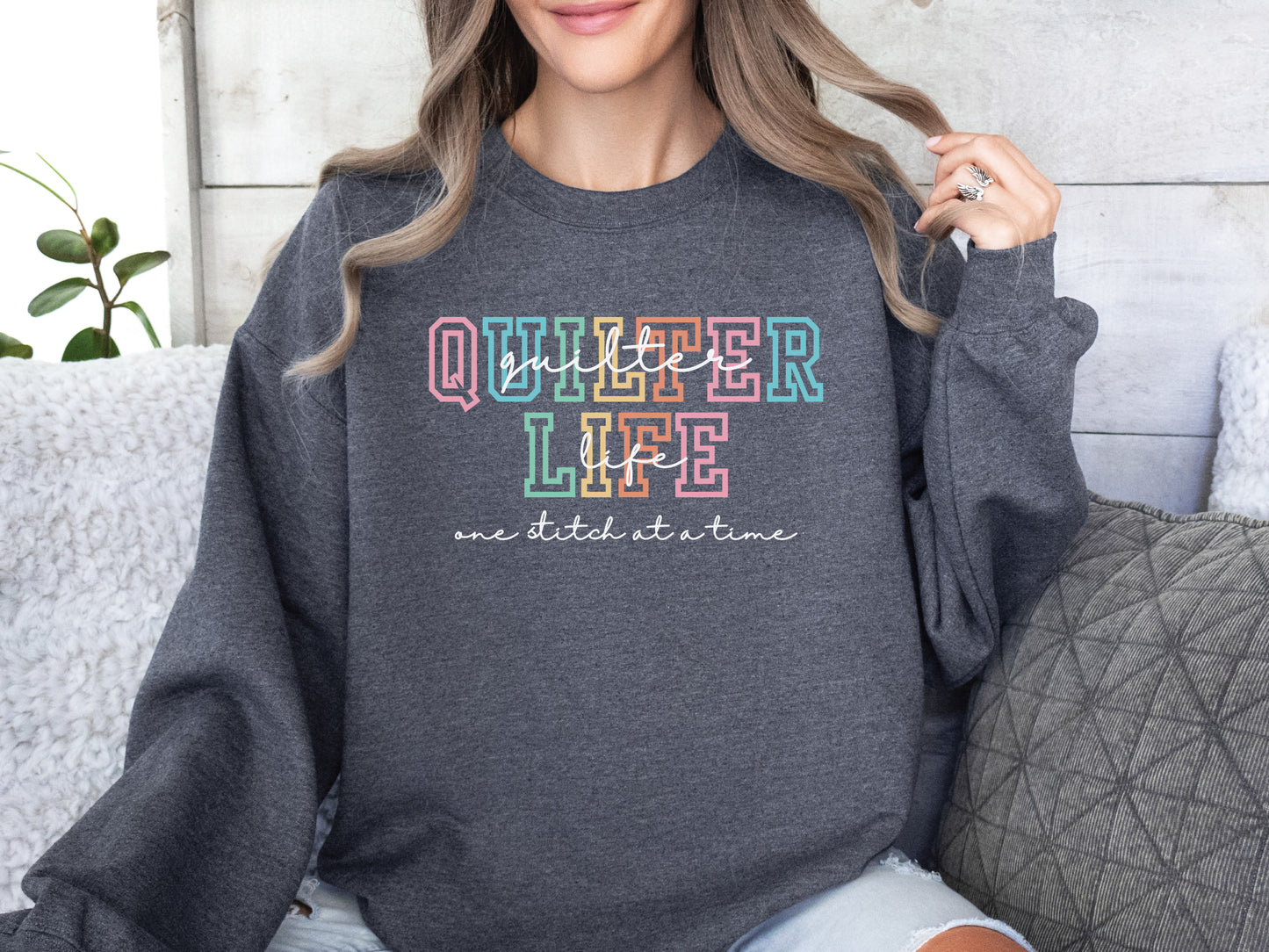 Sweatshirt with varsity-style lettering that reads “Quilter Life: One Stitch at a Time” — cozy and creative gift for quilters and sewing enthusiasts.