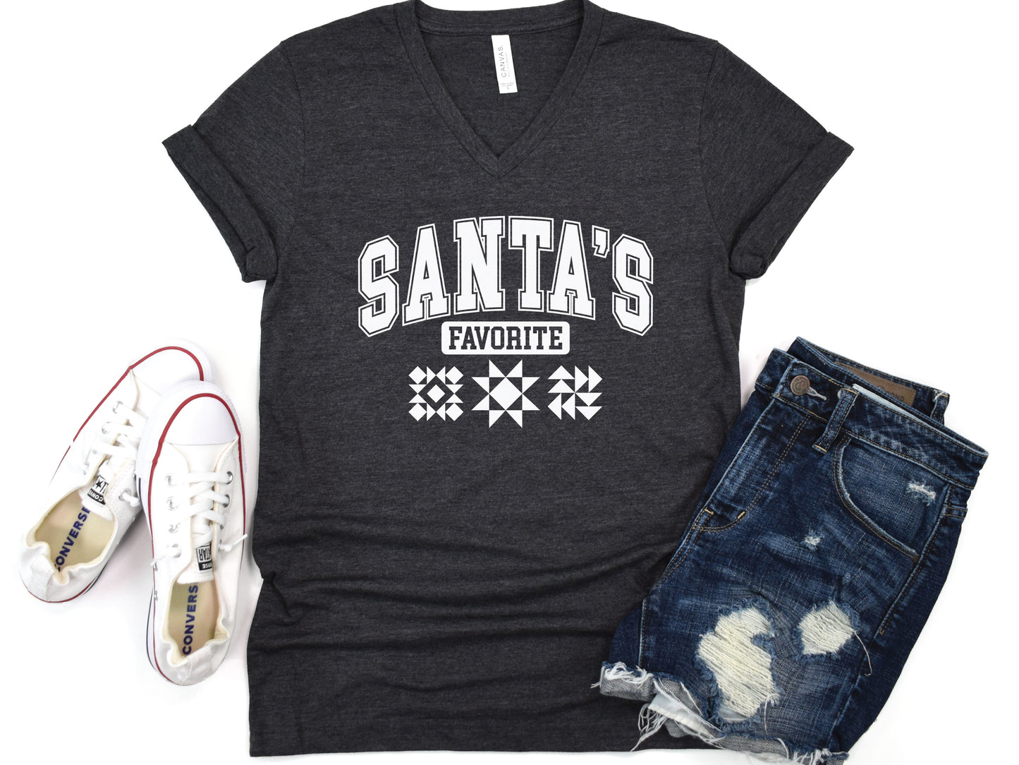 Festive V-Neck short sleeve t-shirt with the phrase “Santa’s Favorite” in bold varsity letters and three quilt block designs, styled for quilters who love Christmas and handmade gifts.