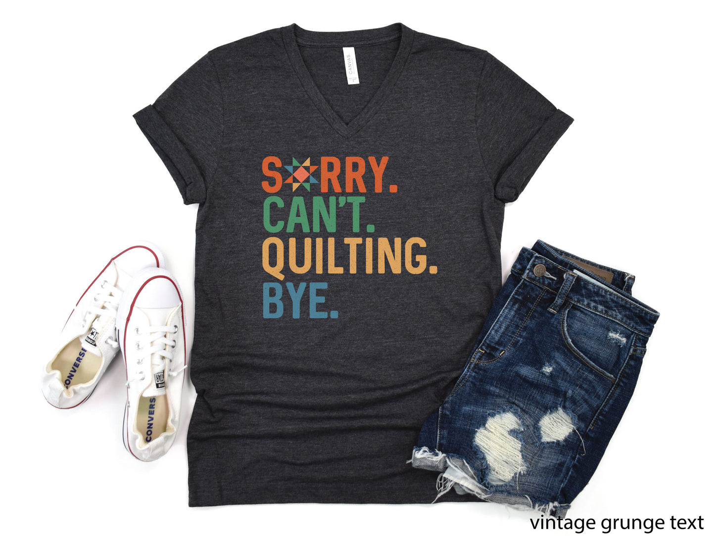 Funny “Sorry, Can’t. Quilting. Bye.” V-neck T-shirt with distressed vintage-style lettering, shown on a dark heather gray shirt — a humorous gift for sewing and quilting lovers.