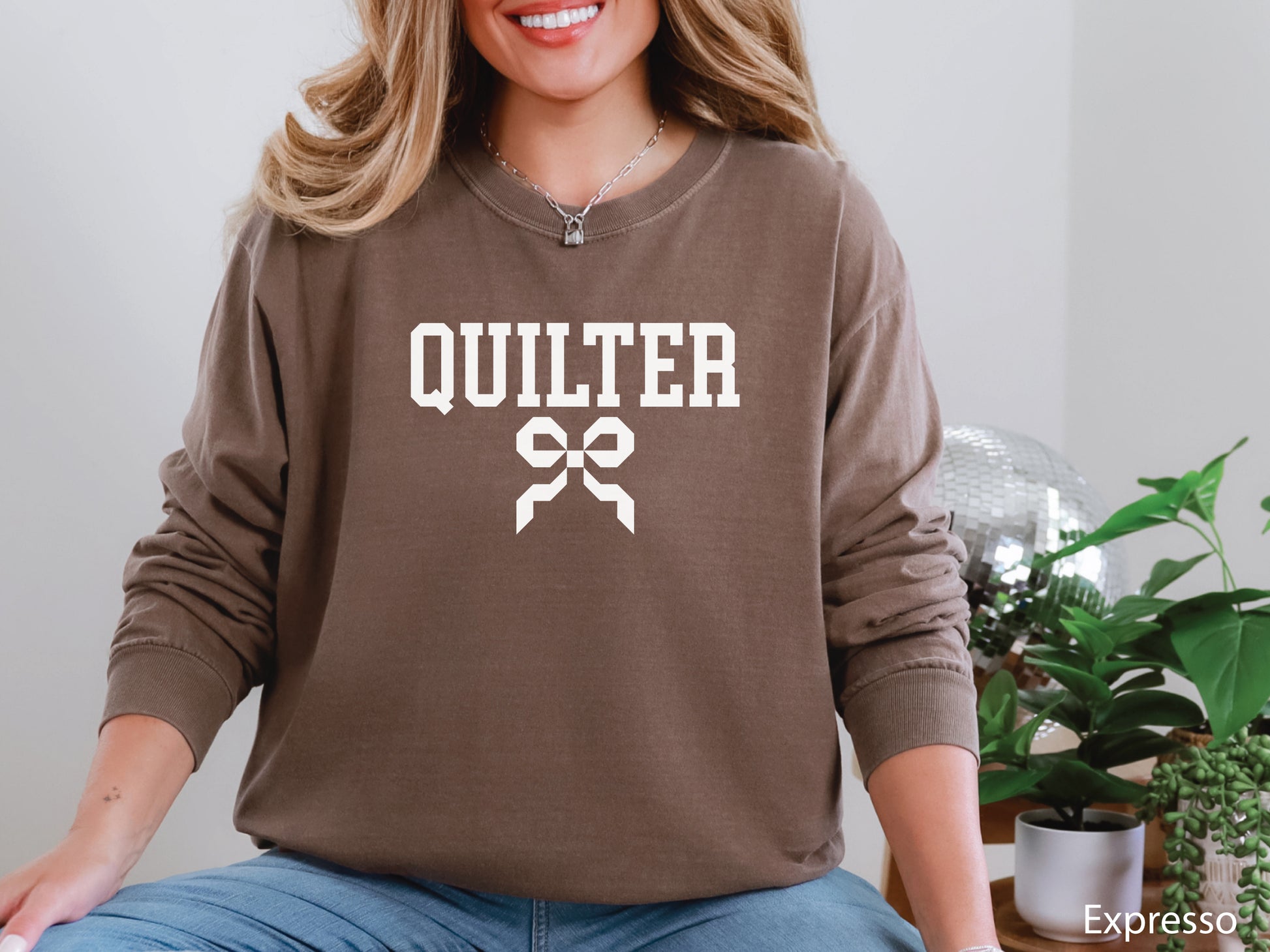 Cozy sweatshirt with bold varsity-style “Quilter” lettering and a coquette bow — perfect for quilt retreats, guild meetings, or as a thoughtful gift for quilters.