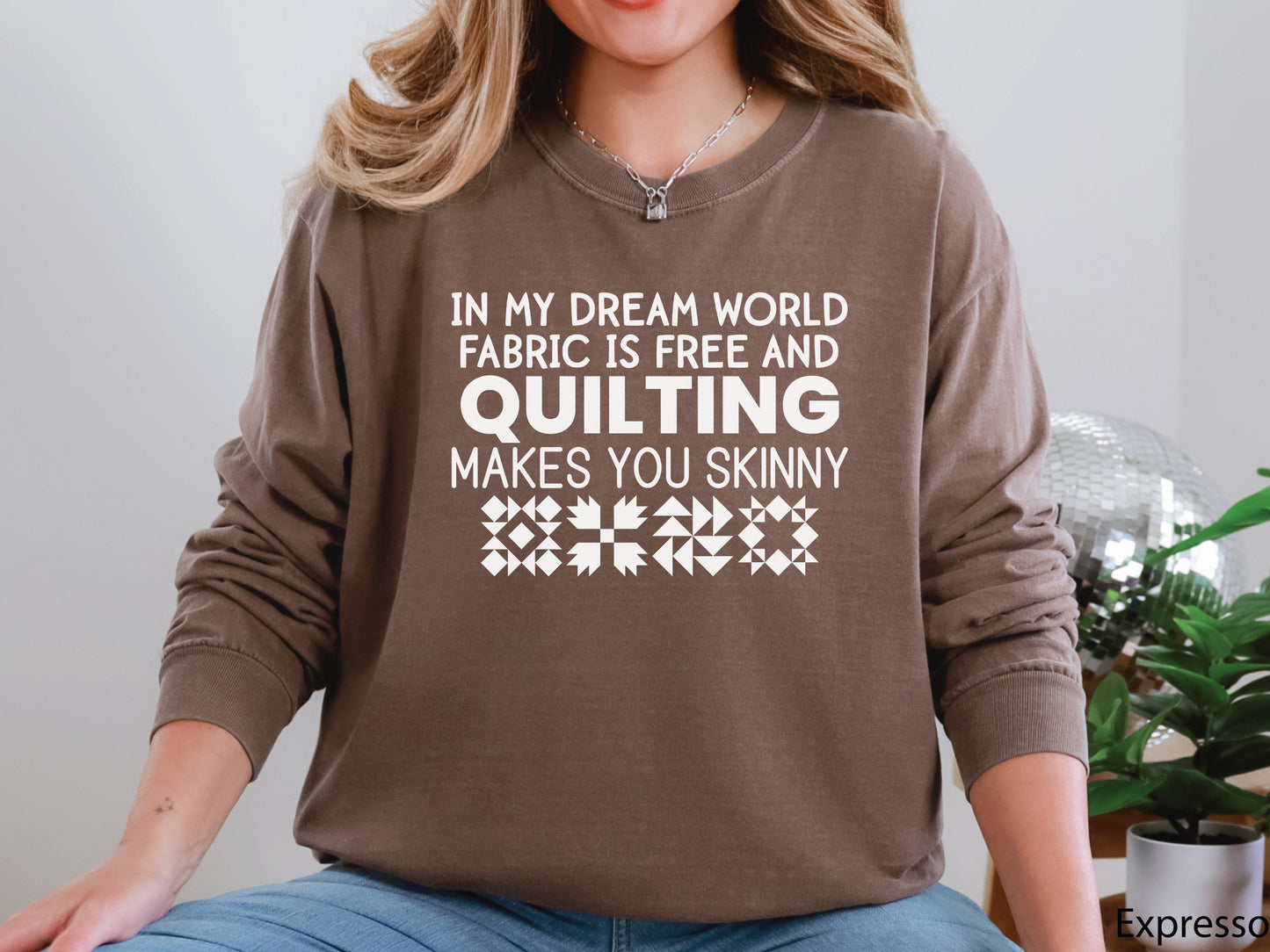 Funny quilter sweatshirt with the phrase “In My Dream World, Fabric Is Free and Quilting Makes You Skinny,” featuring quilt block designs and cozy long sleeves.