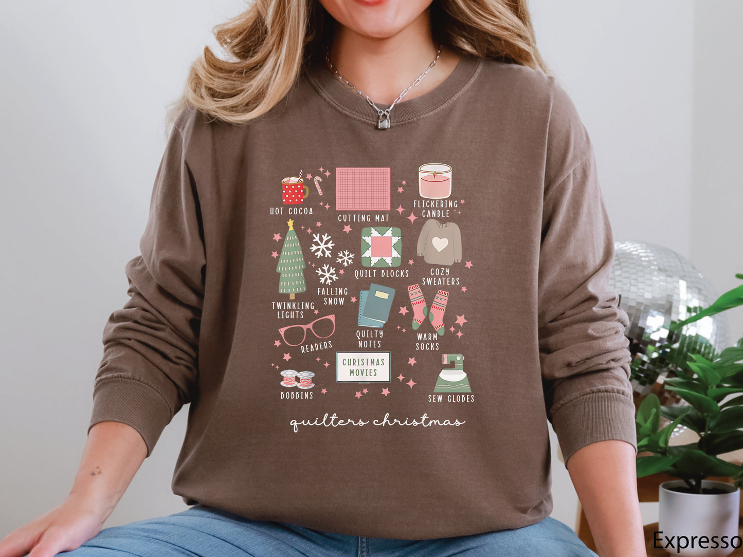 T-shirt with festive “Quilter’s Christmas” icons including quilt blocks, cocoa, lights, sweaters, and sewing items — perfect holiday gift for quilters and sewing lovers.