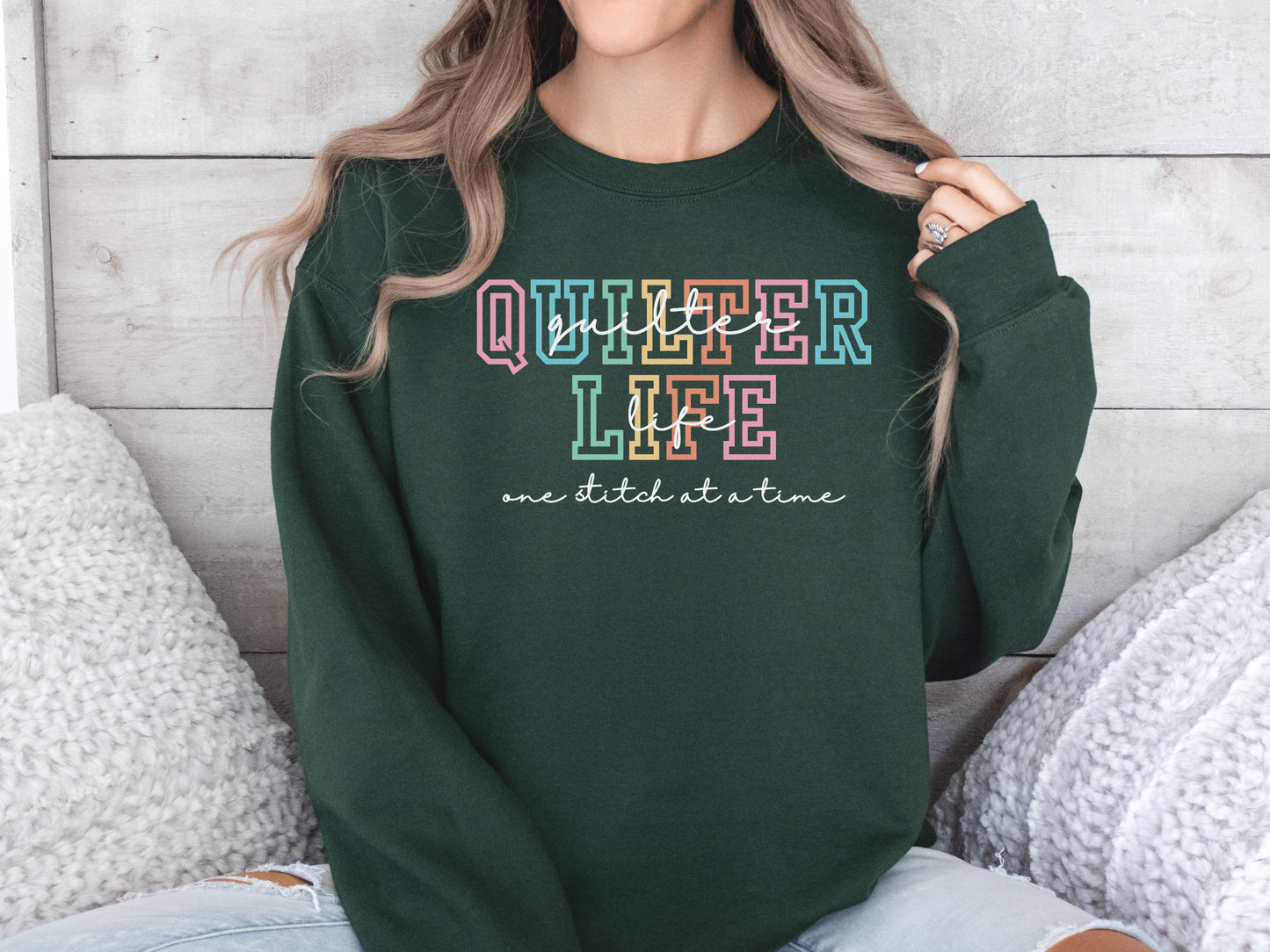 Sweatshirt with varsity-style lettering that reads “Quilter Life: One Stitch at a Time” — cozy and creative gift for quilters and sewing enthusiasts.