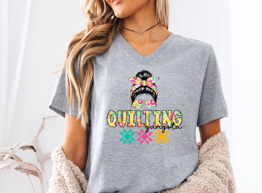 Heather Grey t-shirt featuring a stylish messy bun with a floral headband and sunglasses above the words "Quilting Gangsta," accented with colorful quilt blocks, perfect for quilters with a playful sense of humor.