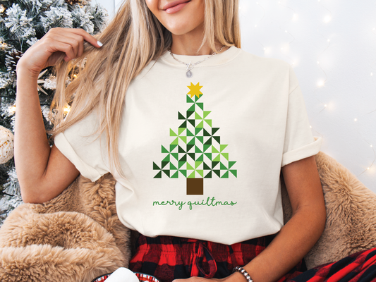 Merry Quiltmas t-shirt in Ivory with quilt block Christmas tree design in green pinwheel blocks topped with gold star—holiday gift for quilters. Shop at Bee Inspired Tees for sewing and quilt-themed short and long sleeve t-shirts, gifts, and stickers designed for passionate sewists and quilters.