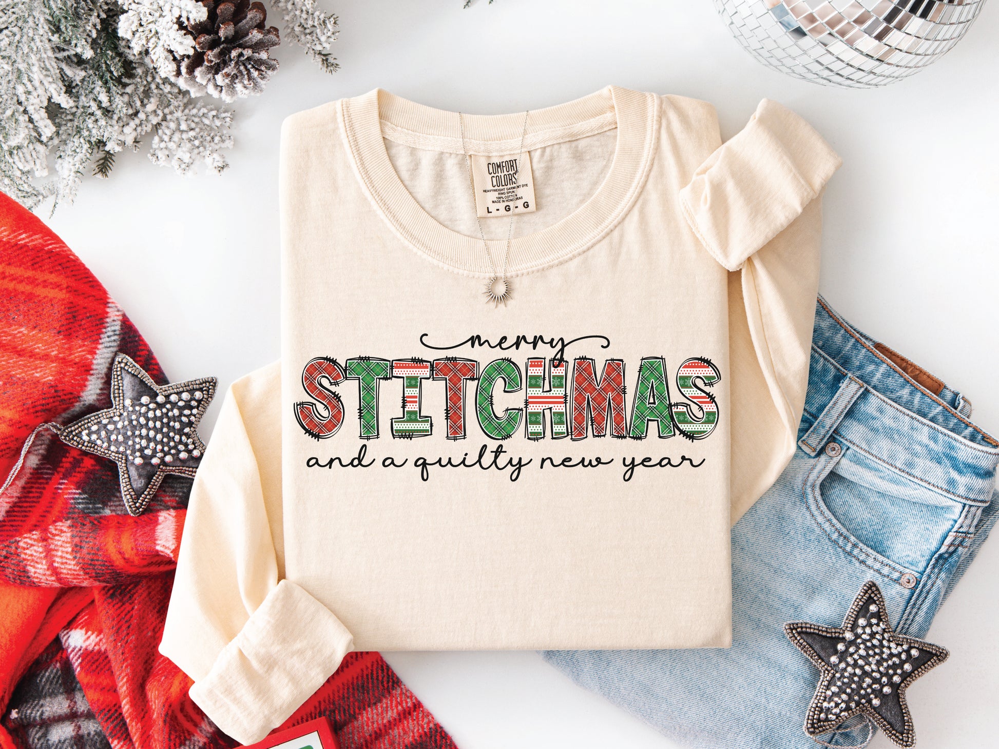 Festive Merry Stitchmas & a Quilty New Year t-shirt with red, green patchwork lettering—perfect holiday gift for quilters and sewists.