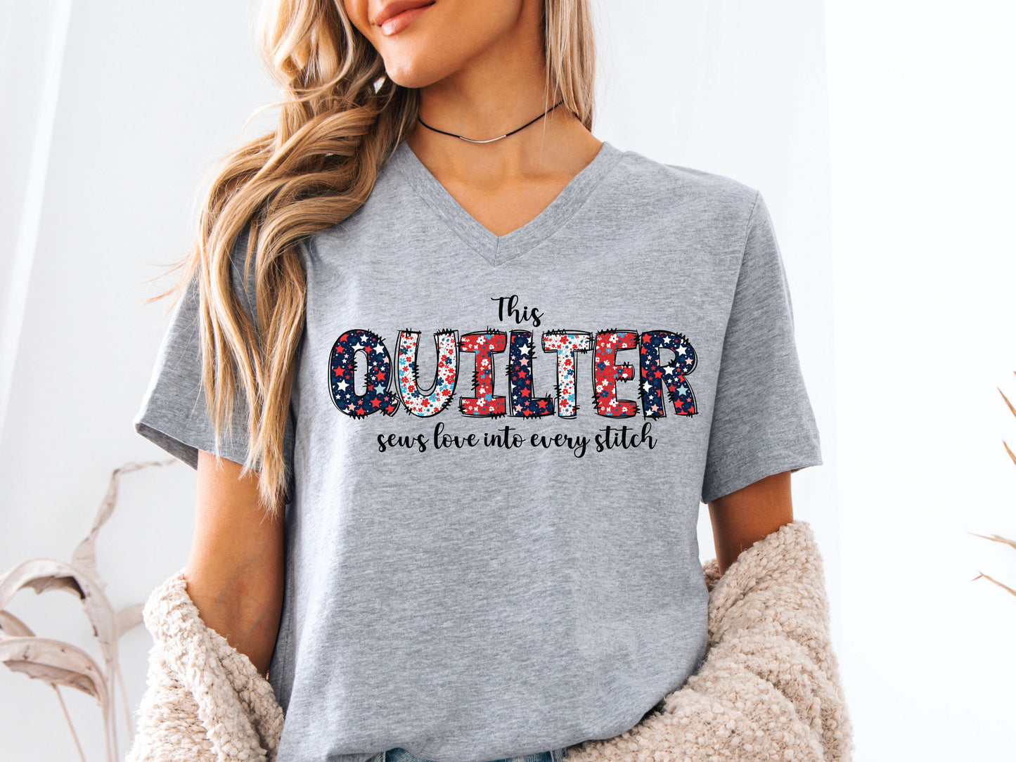 Patriotic quilting t-shirt with the phrase “This Quilter Sews Love Into Every Stitch” in red, white, and blue patchwork lettering, perfect for celebrating America’s 250th Anniversary.