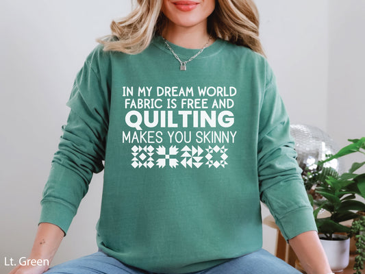 Funny quilter sweatshirt with the phrase “In My Dream World, Fabric Is Free and Quilting Makes You Skinny,” featuring quilt block designs and cozy long sleeves.