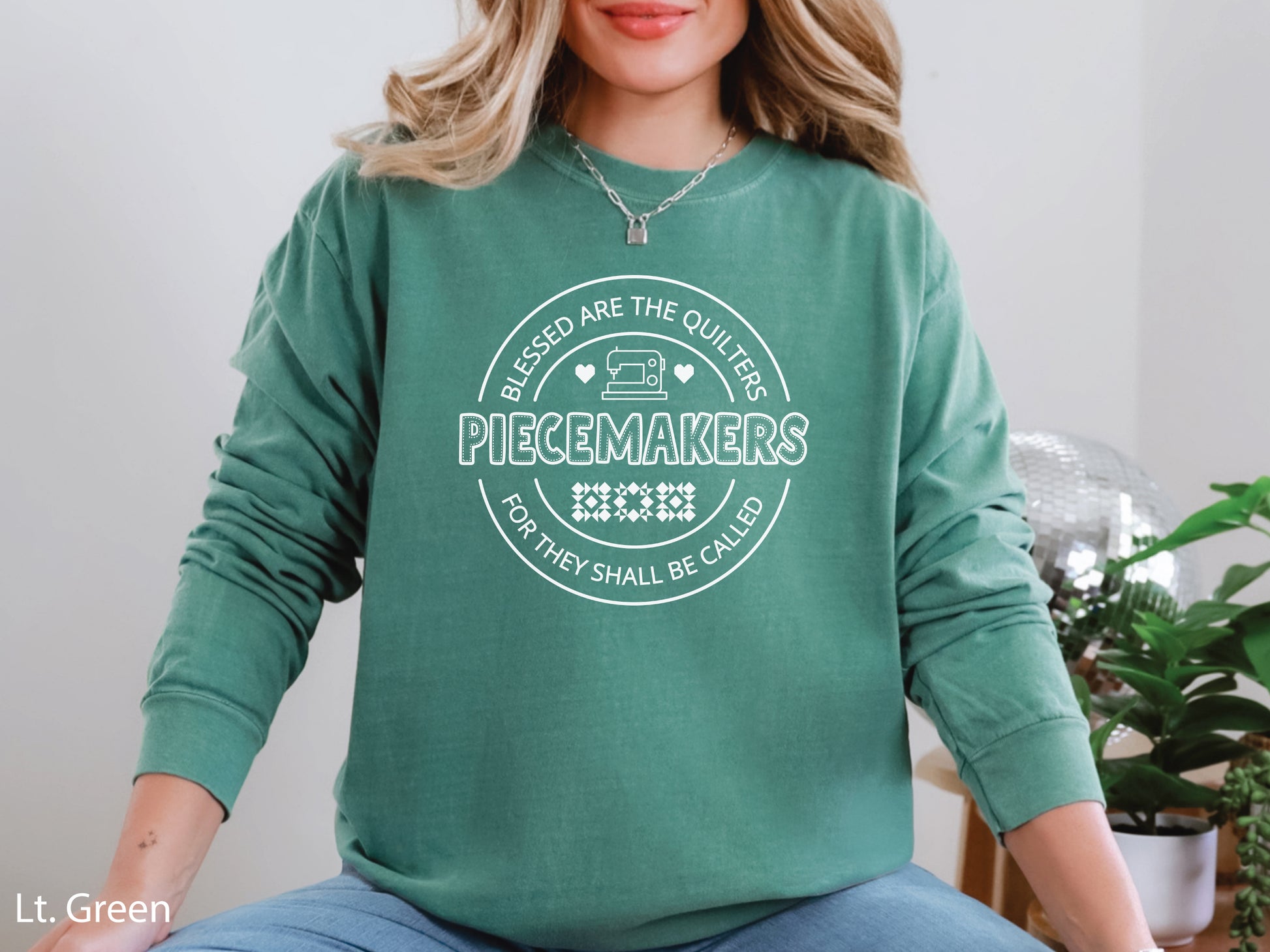A long-sleeve quilting t-shirt from Bee Inspired Tees featuring the phrase “Piecemaker – Quilters Are Blessed,” celebrating creativity, faith, and the art of quilting; a cozy gift for quilters and perfect for retreats or sewing days.