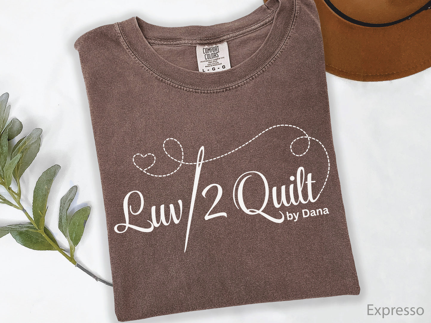 Official Luv2Quilt by Dana quilting-themed t-shirt featuring the Luv2Quilt logo with a sewing needle and stitched heart design, perfect for quilt classes, retreats, and everyday wear.