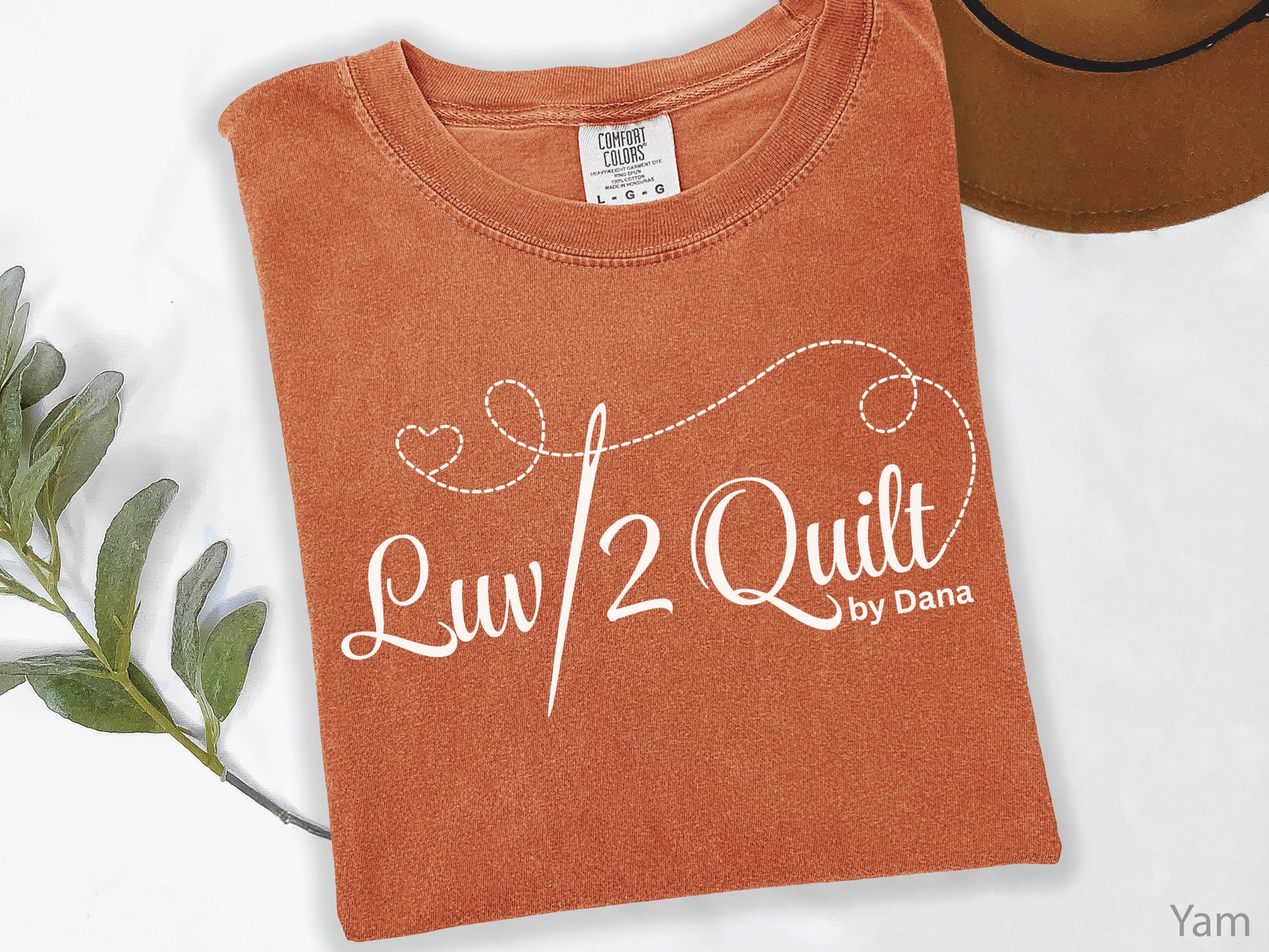 Official Luv2Quilt by Dana quilting-themed t-shirt featuring the Luv2Quilt logo with a sewing needle and stitched heart design, perfect for quilt classes, retreats, and everyday wear.