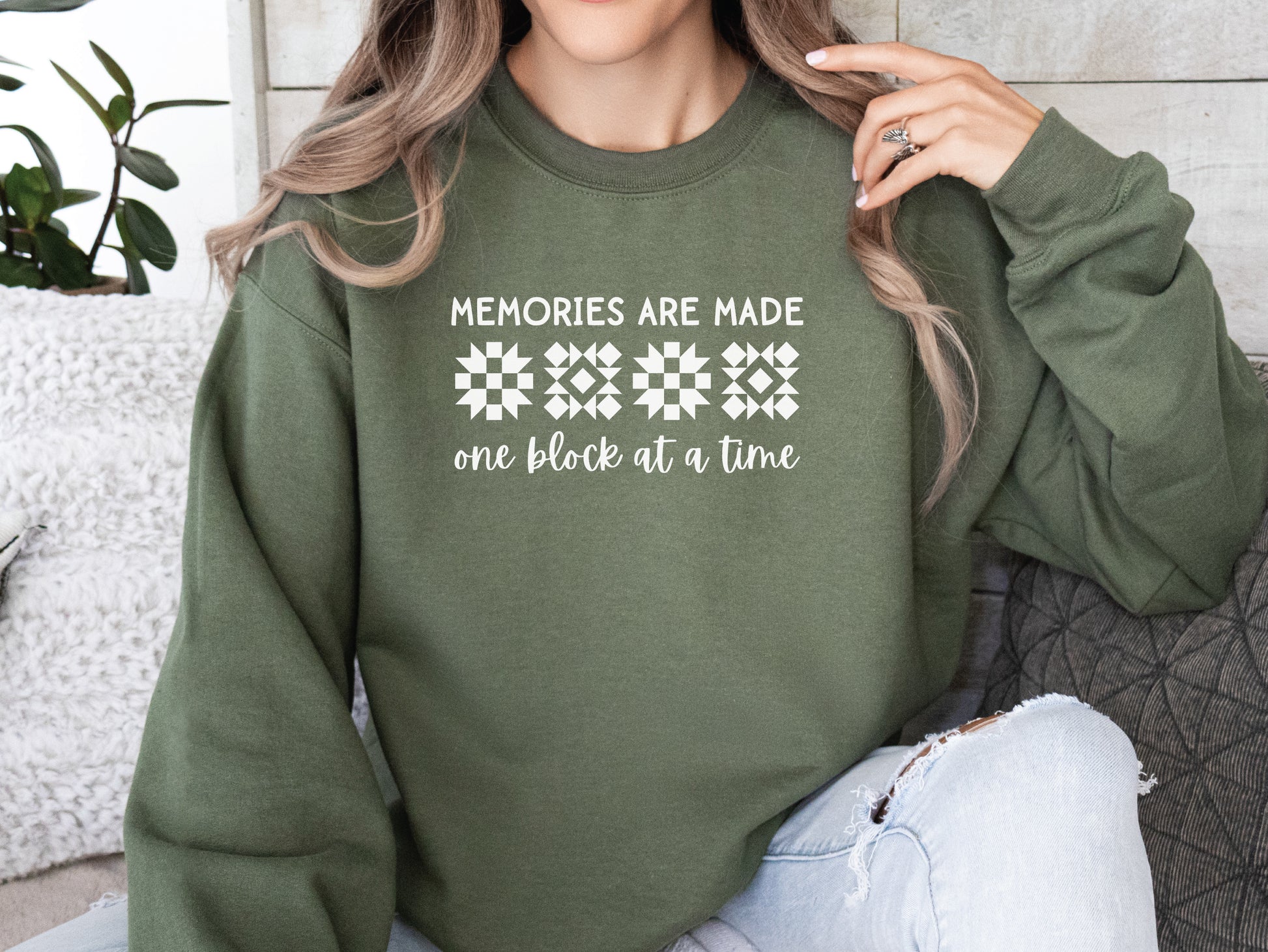 A long-sleeve quilt-themed sweatshirt from Bee Inspired Tees featuring the phrase “Memories Are Made One Block at a Time,” perfect for cozy sewing days, quilt retreats, or gifting to quilters who love celebrating their craft.