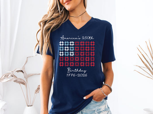 Celebrate America’s 250th Birthday with this “Quiltin’ USA” patriotic quilting v-neck tee shirt. Featuring red, white, and blue quilt blocks with a commemorative Americana design.