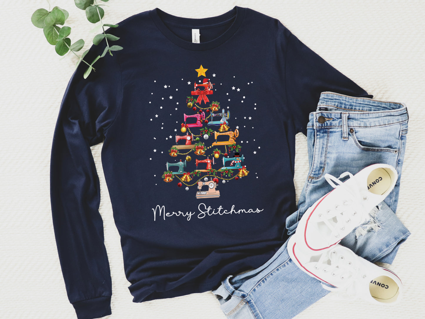 Navy long sleeve shirt with a Christmas tree made of colorful sewing machines and the words “Merry Stitchmas” — festive holiday gift for quilters and sewists.