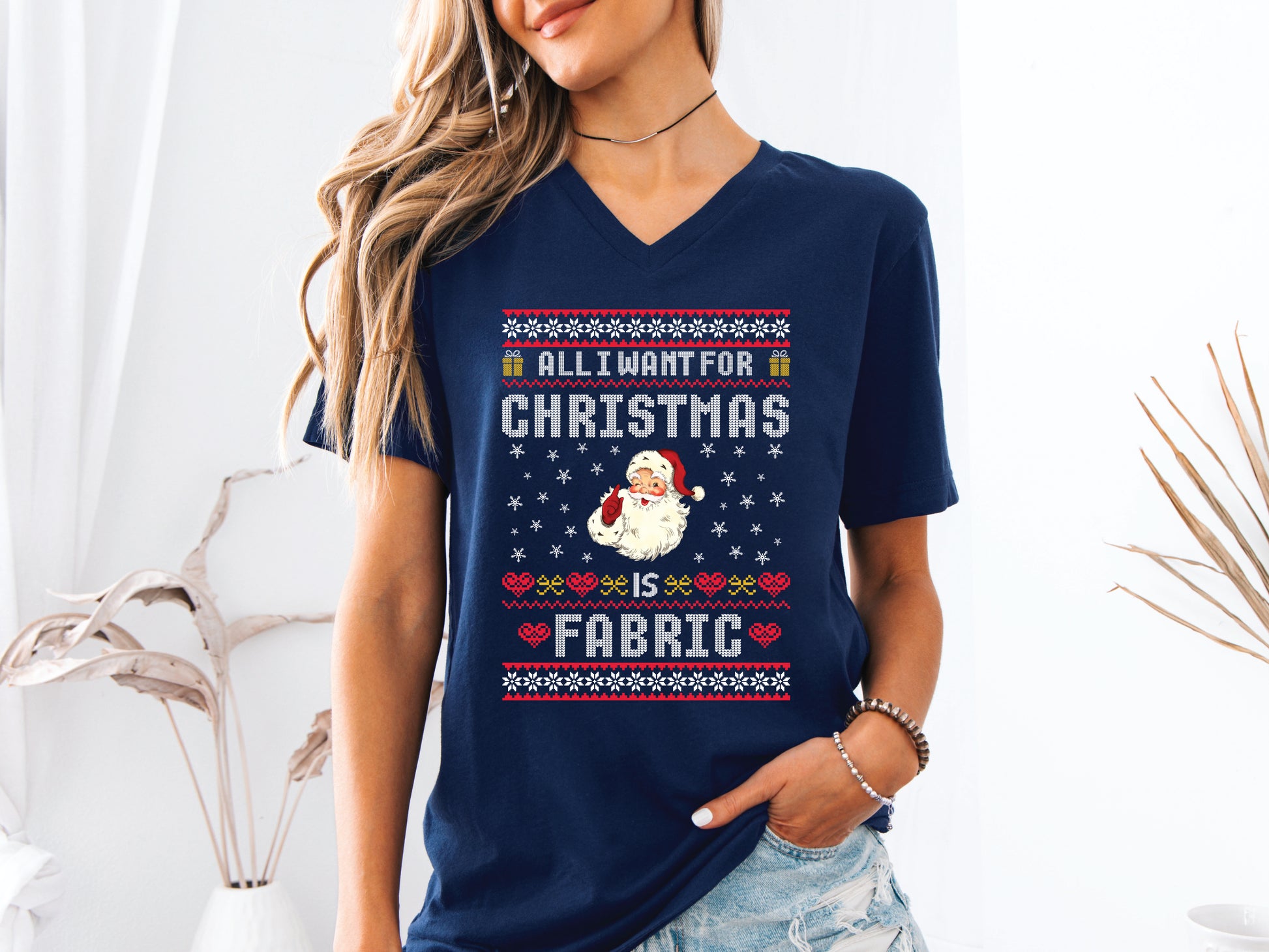 V-neck t-shirt with vintage Santa and stitch-style “All I Want for Christmas Is Fabric” design — fun holiday gift for quilters and sewing lovers.
