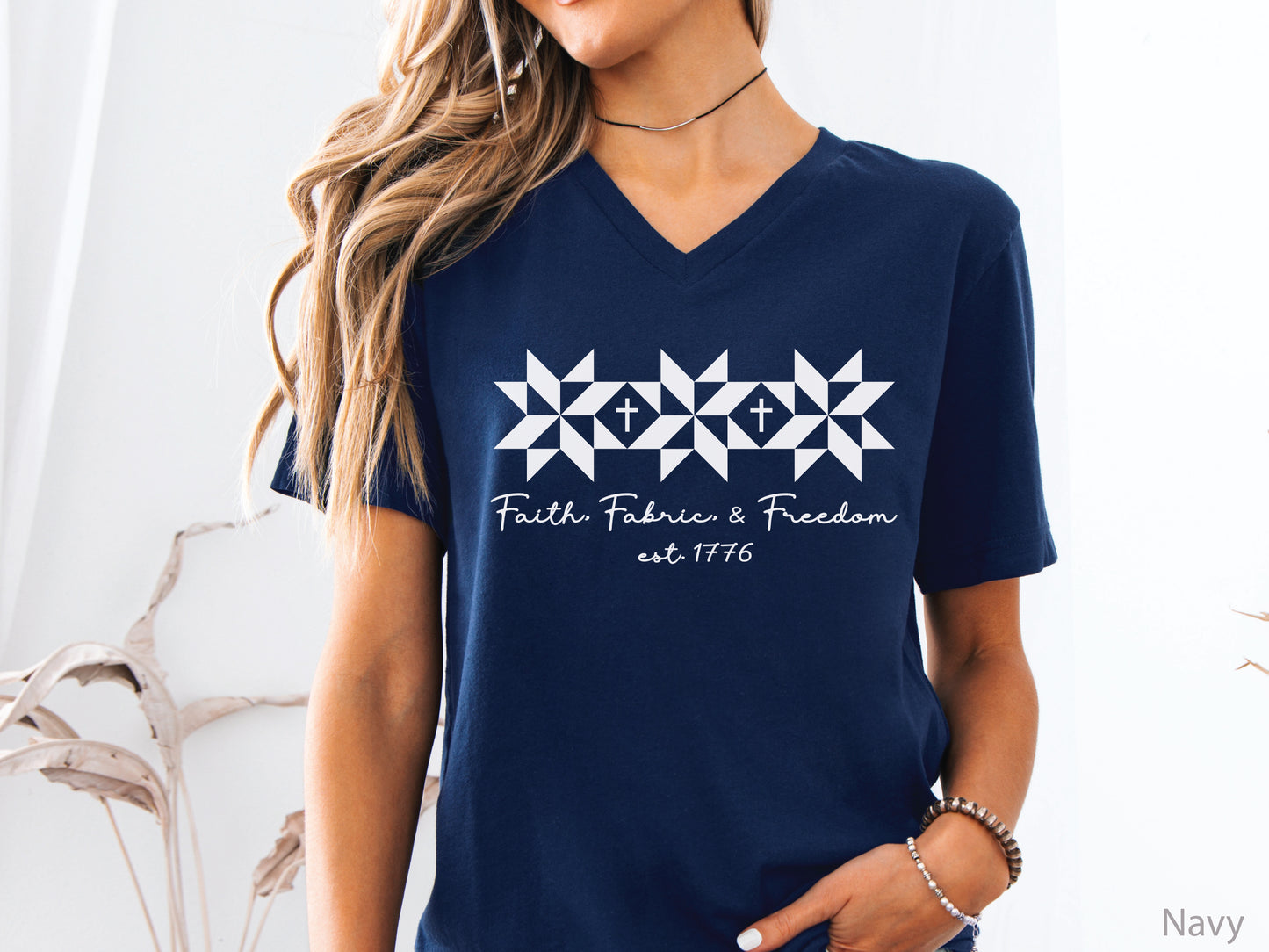 Faith, Fabric & Freedom patriotic v-neck t-shirt with quilt block stars and cross details. Perfect for quilters, sewists, and faith-based gifts.