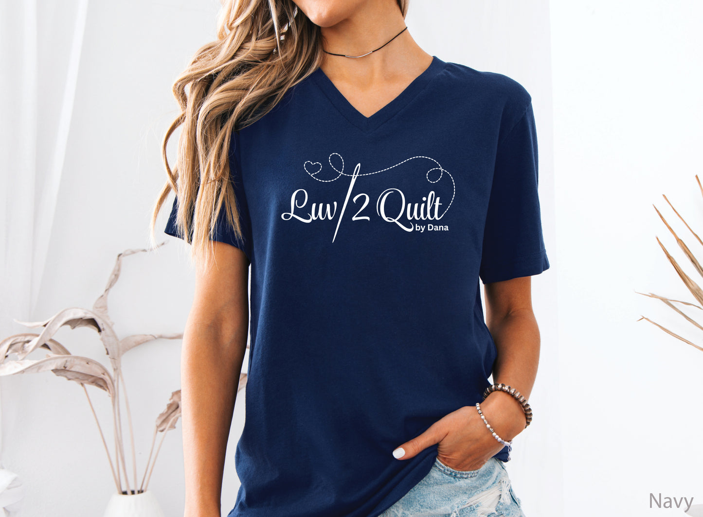 Official Luv2Quilt by Dana quilting-themed t-shirt featuring the Luv2Quilt logo with a sewing needle and stitched heart design, perfect for quilt classes, retreats, and everyday wear.