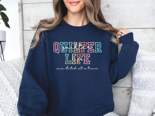 Sweatshirt with varsity-style lettering that reads “Quilter Life: One Stitch at a Time” — cozy and creative gift for quilters and sewing enthusiasts.