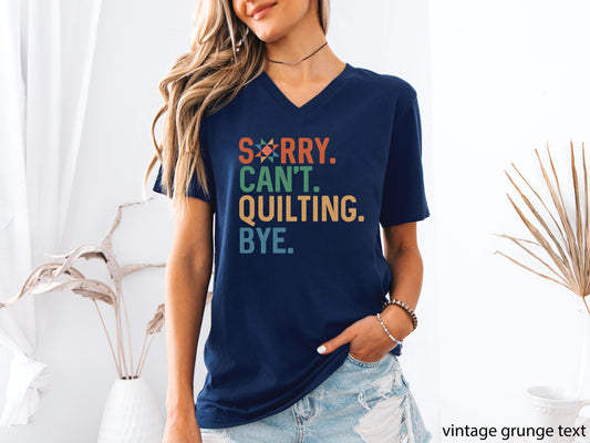 Funny “Sorry, Can’t. Quilting. Bye.” V-neck T-shirt with distressed vintage-style lettering, shown on a navy shirt — a humorous gift for sewing and quilting lovers.