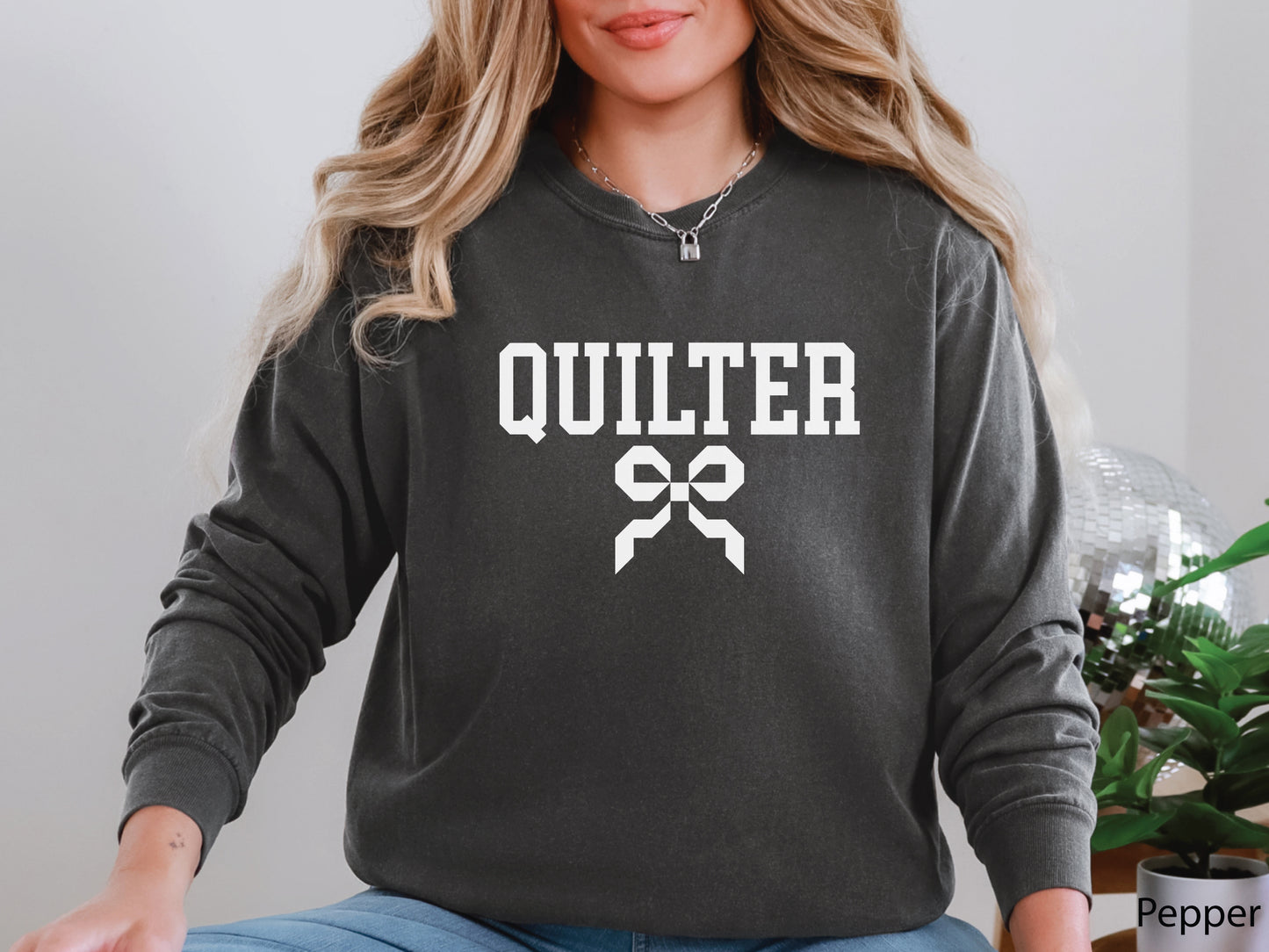 Cozy sweatshirt with bold varsity-style “Quilter” lettering and a coquette bow — perfect for quilt retreats, guild meetings, or as a thoughtful gift for quilters.