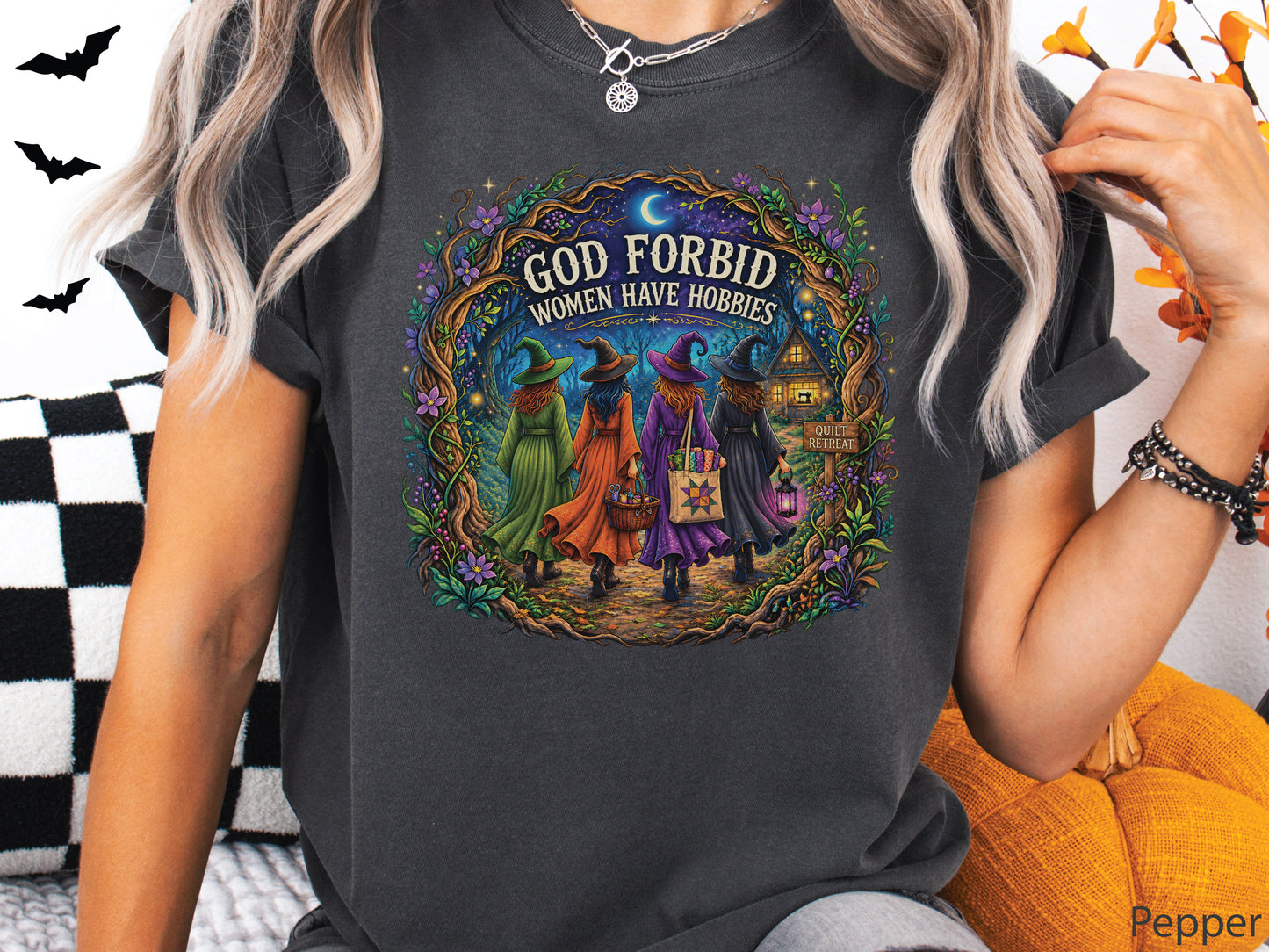 God Forbid Women Have Hobbies Halloween quilting t-shirt featuring four quilty friends dressed as witches walking through an enchanted moonlit forest to a cozy quilt retreat cottage with sewing and quilting details.