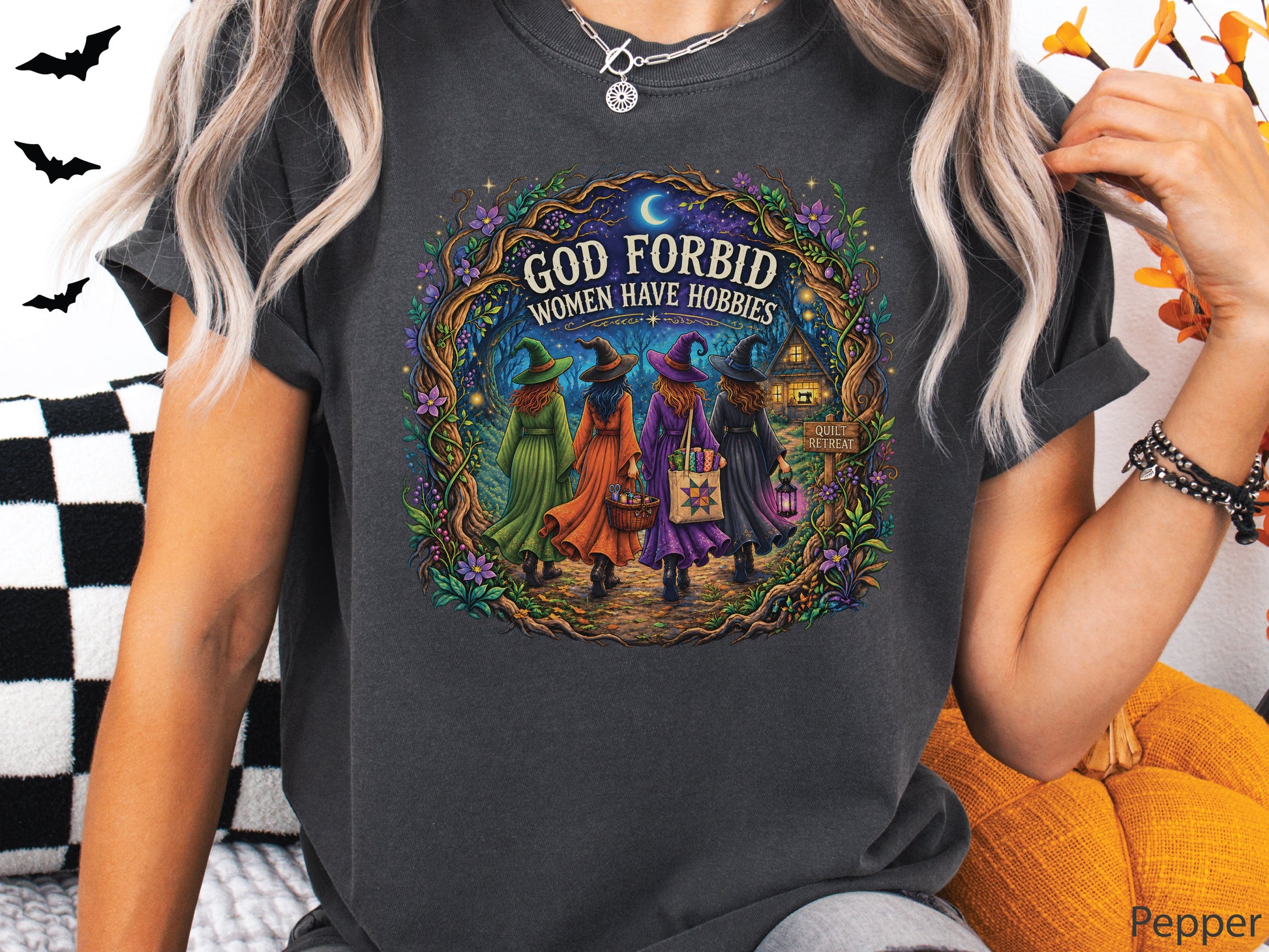 God Forbid Women Have Hobbies Halloween quilting t-shirt featuring four quilty friends dressed as witches walking through an enchanted moonlit forest to a cozy quilt retreat cottage with sewing and quilting details.