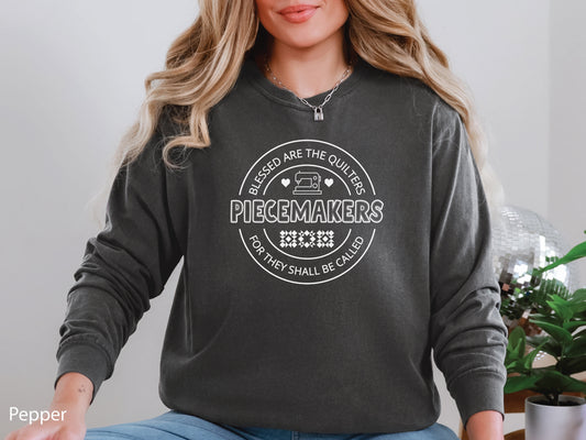 A long-sleeve quilting t-shirt from Bee Inspired Tees featuring the phrase “Piecemaker – Quilters Are Blessed,” celebrating creativity, faith, and the art of quilting; a cozy gift for quilters and perfect for retreats or sewing days.
