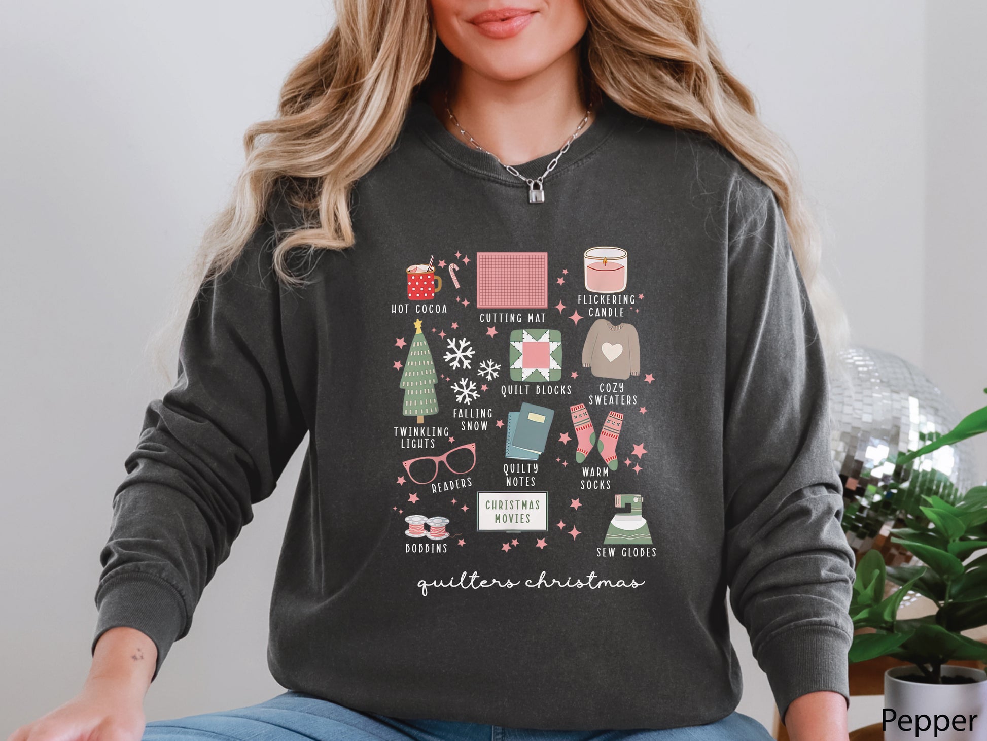 T-shirt with festive “Quilter’s Christmas” icons including quilt blocks, cocoa, lights, sweaters, and sewing items — perfect holiday gift for quilters and sewing lovers.