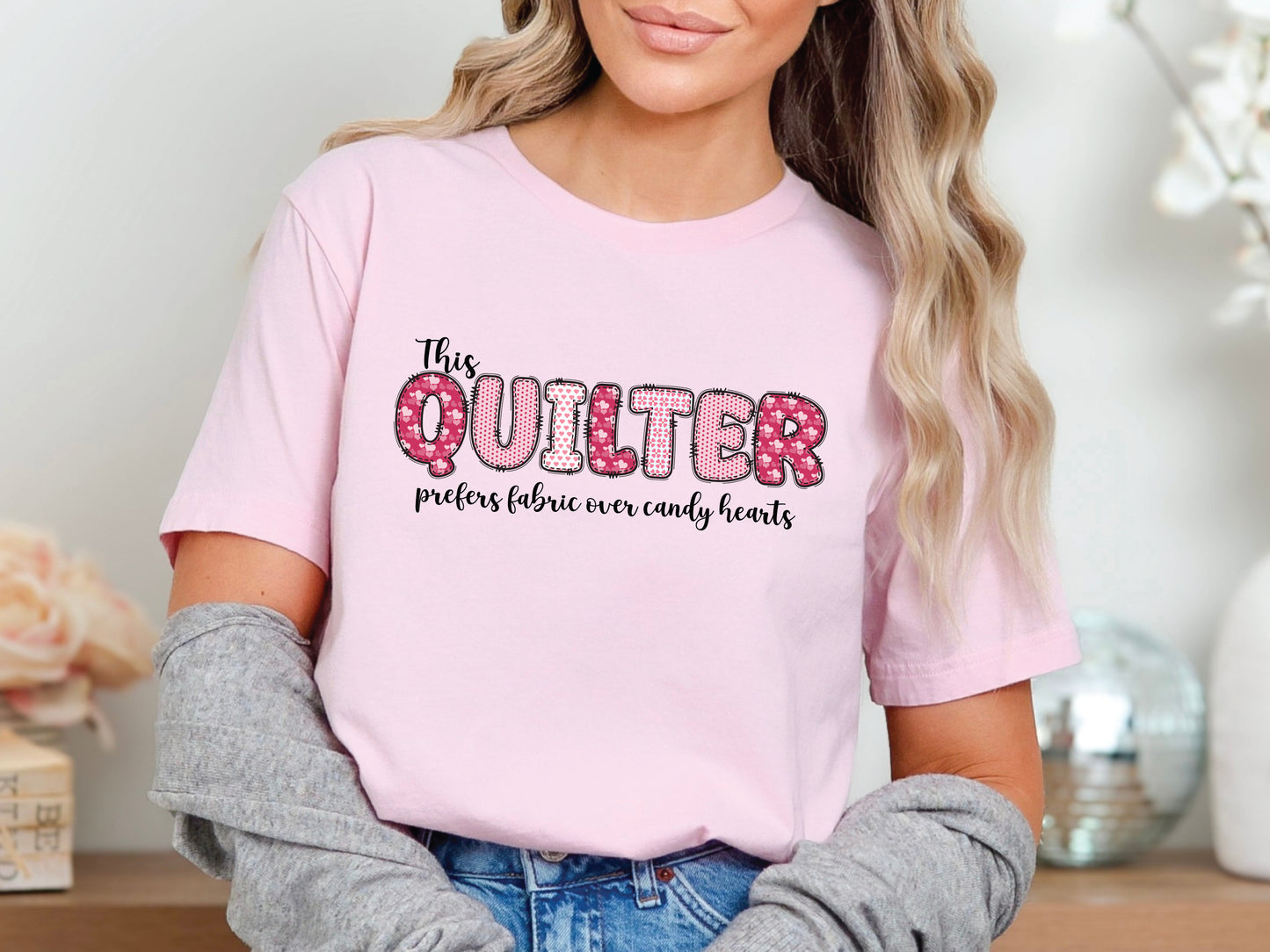 Valentine’s Day quilting t-shirt with the phrase “This Quilter Prefers Fabric Over Candy” in patchwork-style lettering, perfect for quilters.