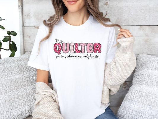 Valentine’s Day quilting t-shirt with the phrase “This Quilter Prefers Fabric Over Candy” in patchwork-style lettering, perfect for quilters.